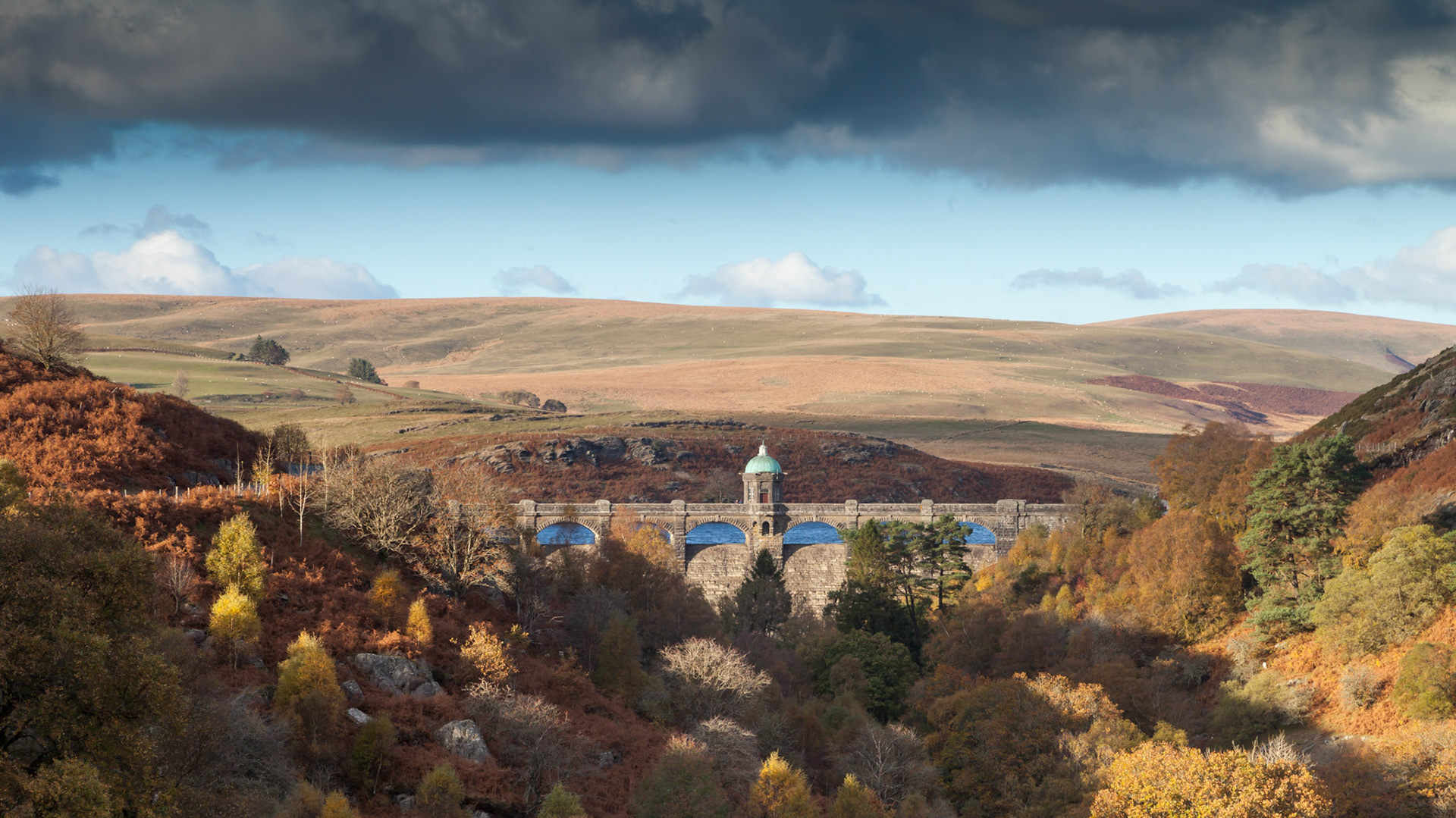 Dam in Elan Valley with trees in autumn colours. Autumn, Powys, Wales, UK