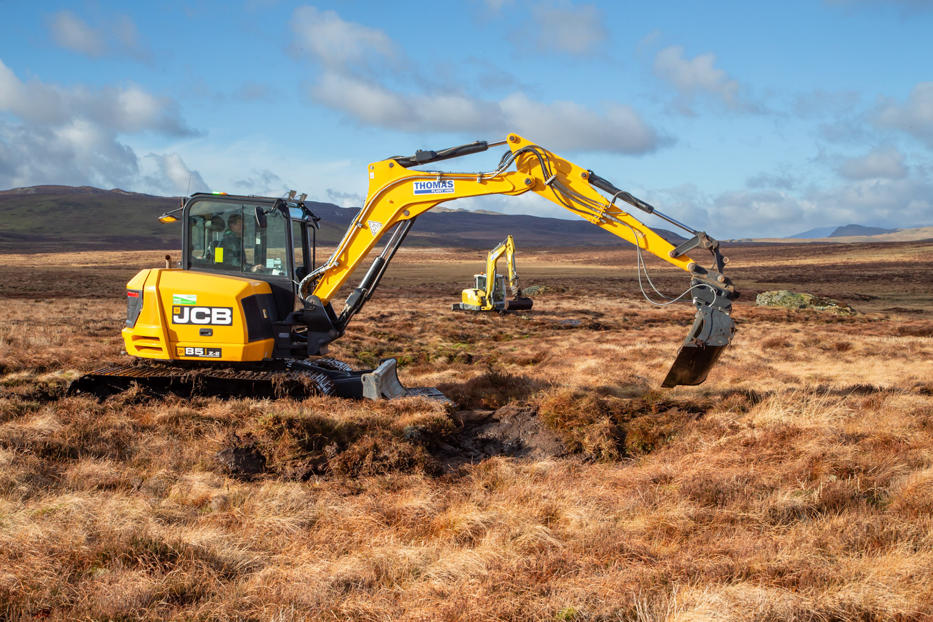 Contractors using diggers to carry out peatland restoration work for RSPB peatland restoration project. Winter, Migneint moors, North Wales,UK.