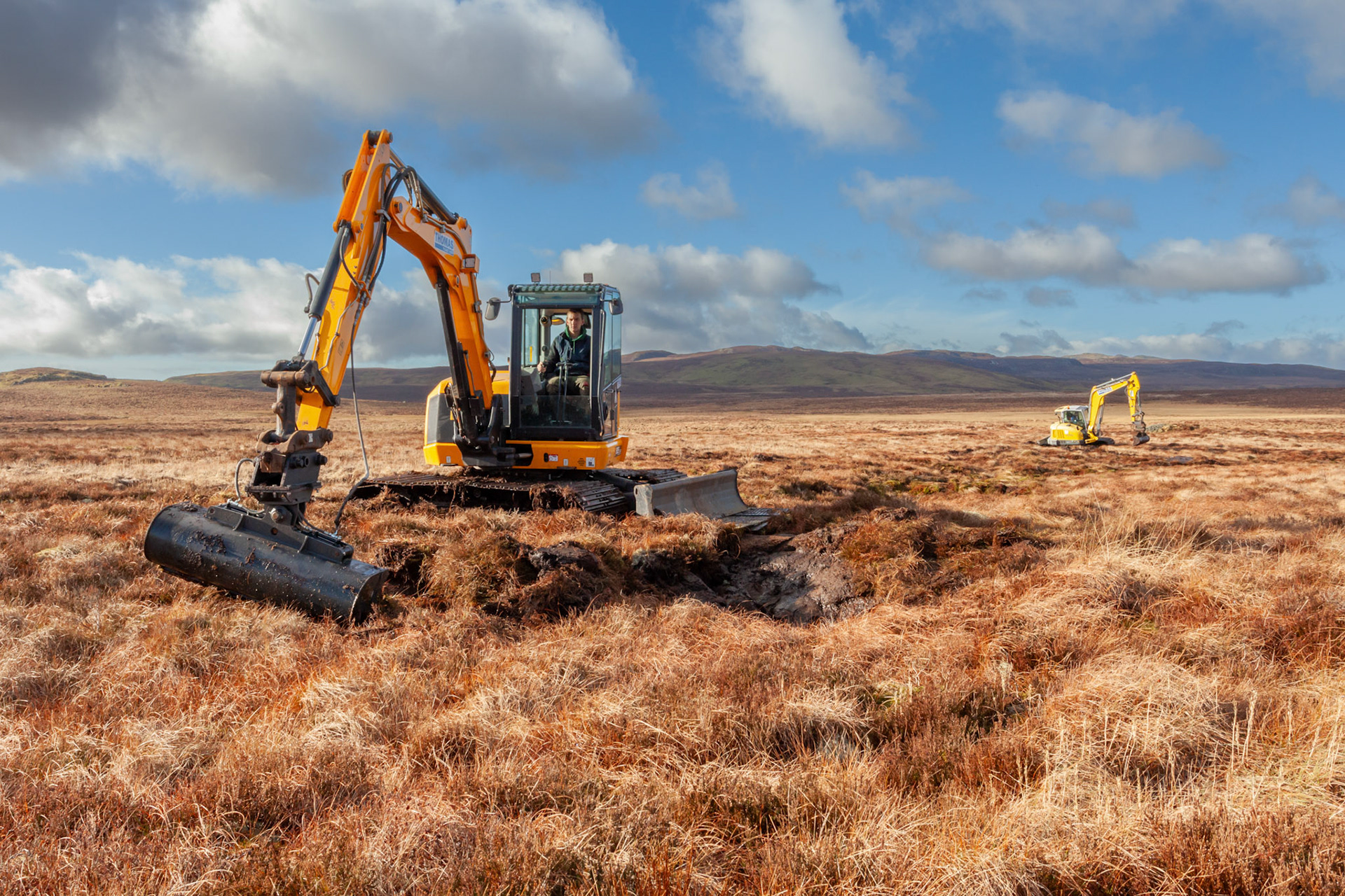 Contractors using diggers to carry out peatland restoration work for RSPB peatland restoration project. Winter, Migneint moors, North Wales,UK.