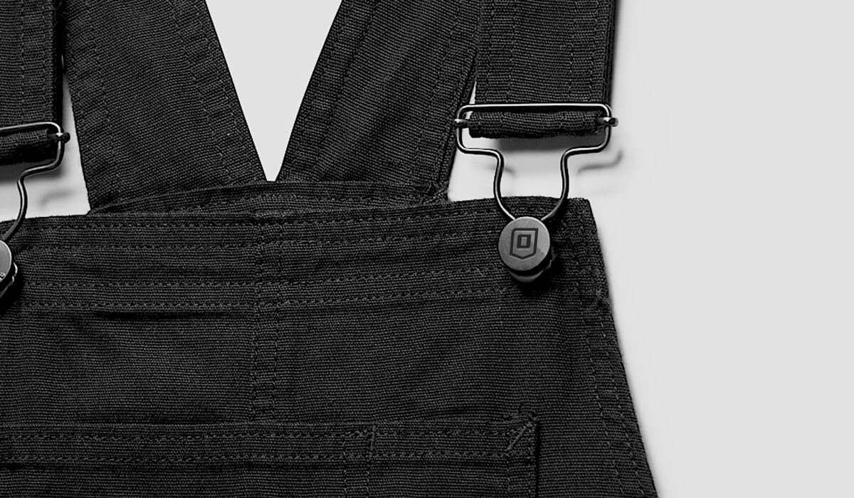 Close-up of Onguard Protective Workwear overall bibs showing debossed brand mark on clip hardware as part of the brand rebrand.