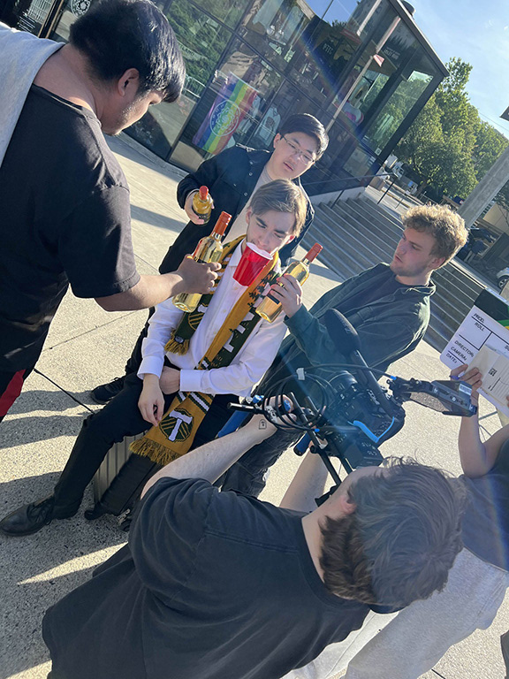 A behind the scenes photo of me operating the camera and directing our actor and crew members on a shot