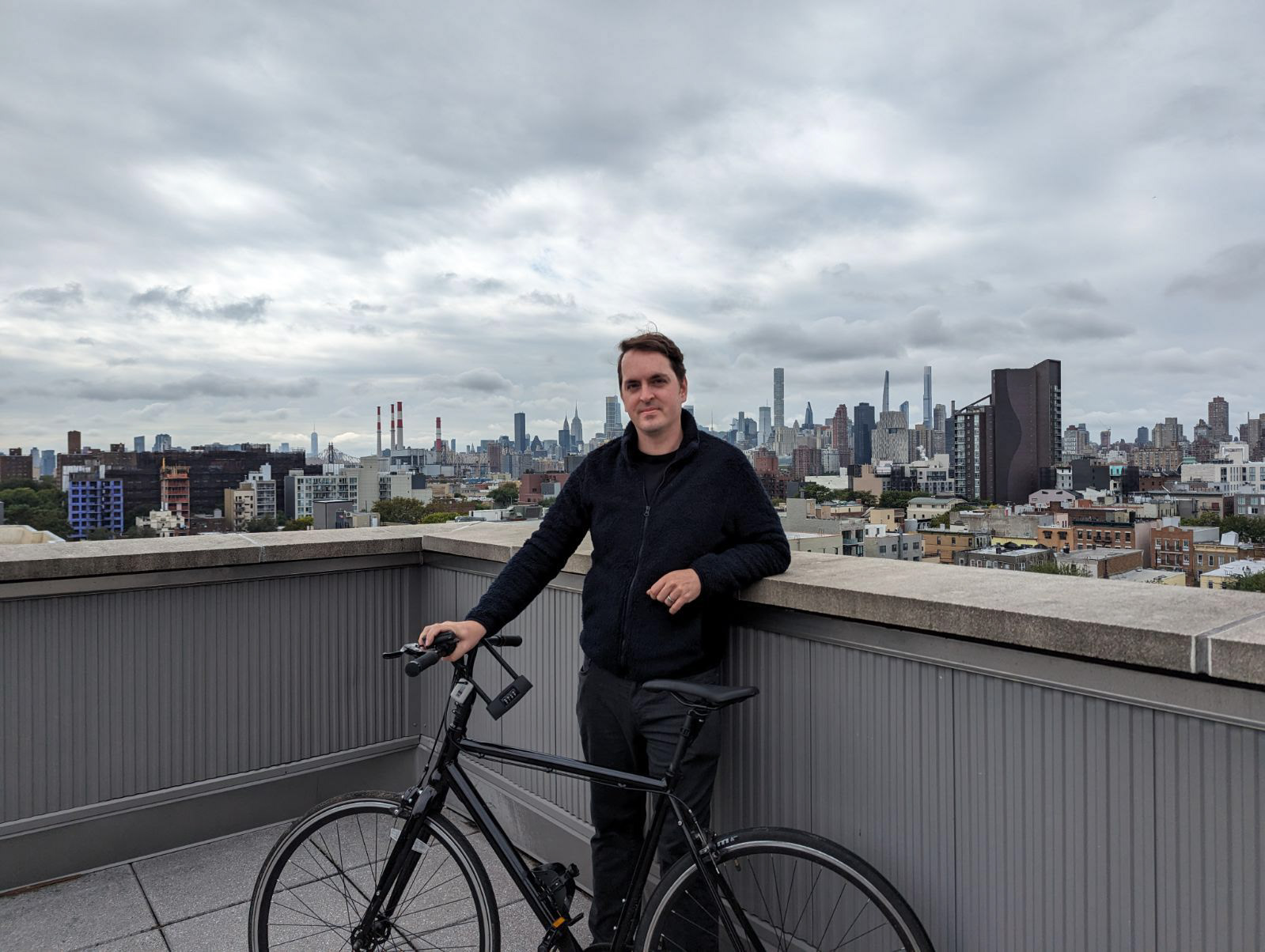 Alex Duncan poses with his bicycle overlooking Astoria and beyond.