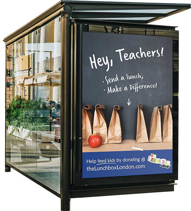 A blue-toned bus shelter advertisement shows a missing lunchbag with an arrow pointing toward it. The text reads, "Send a lunch, make a difference."