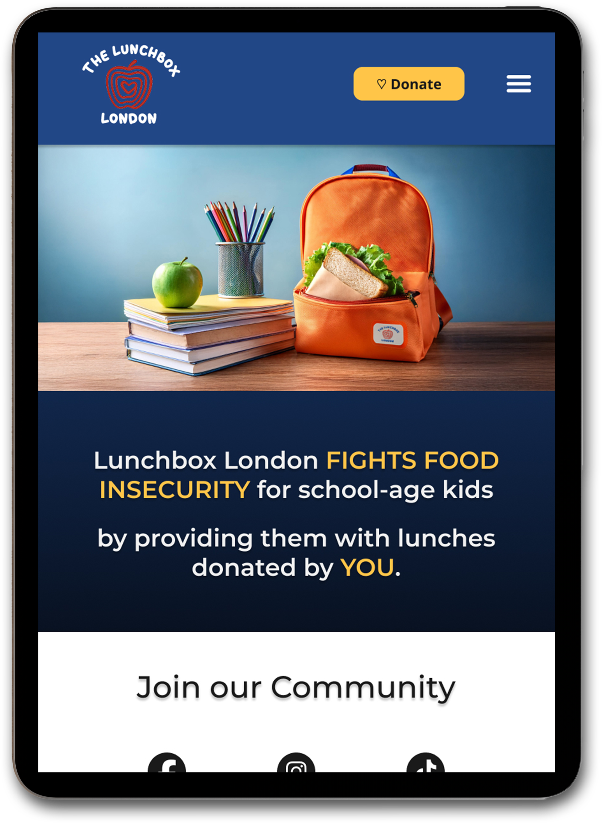 A tablet screen shows the tablet breakpoint of the redesigned Lunchbox London landing page. The hero image features a vibrant orange lunchbag, with books and a green apple beside it.