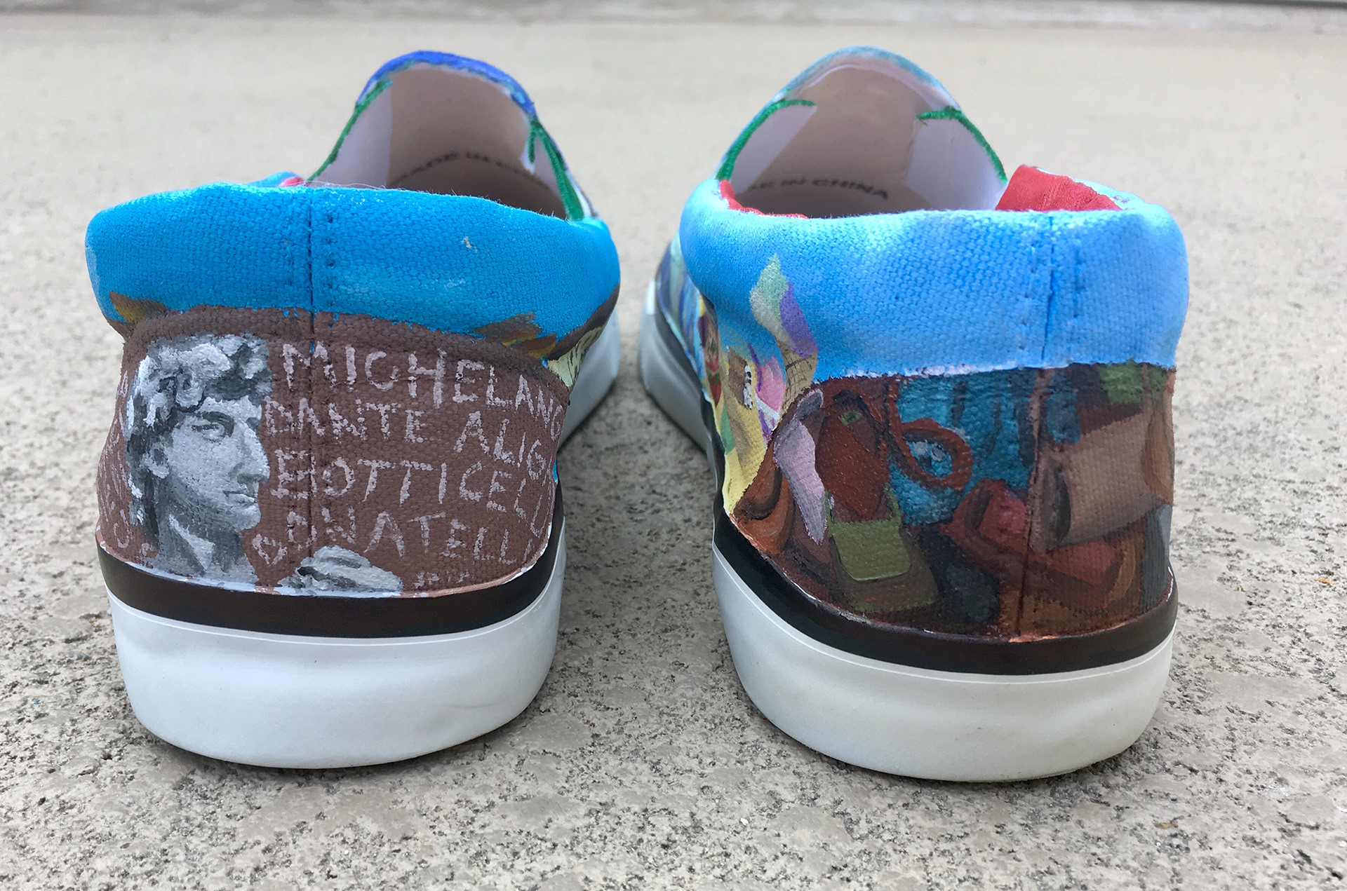 The back features the David sculpture and some famous Florence artists on one shoe, and some of the wares seen at the leather markets on the other.