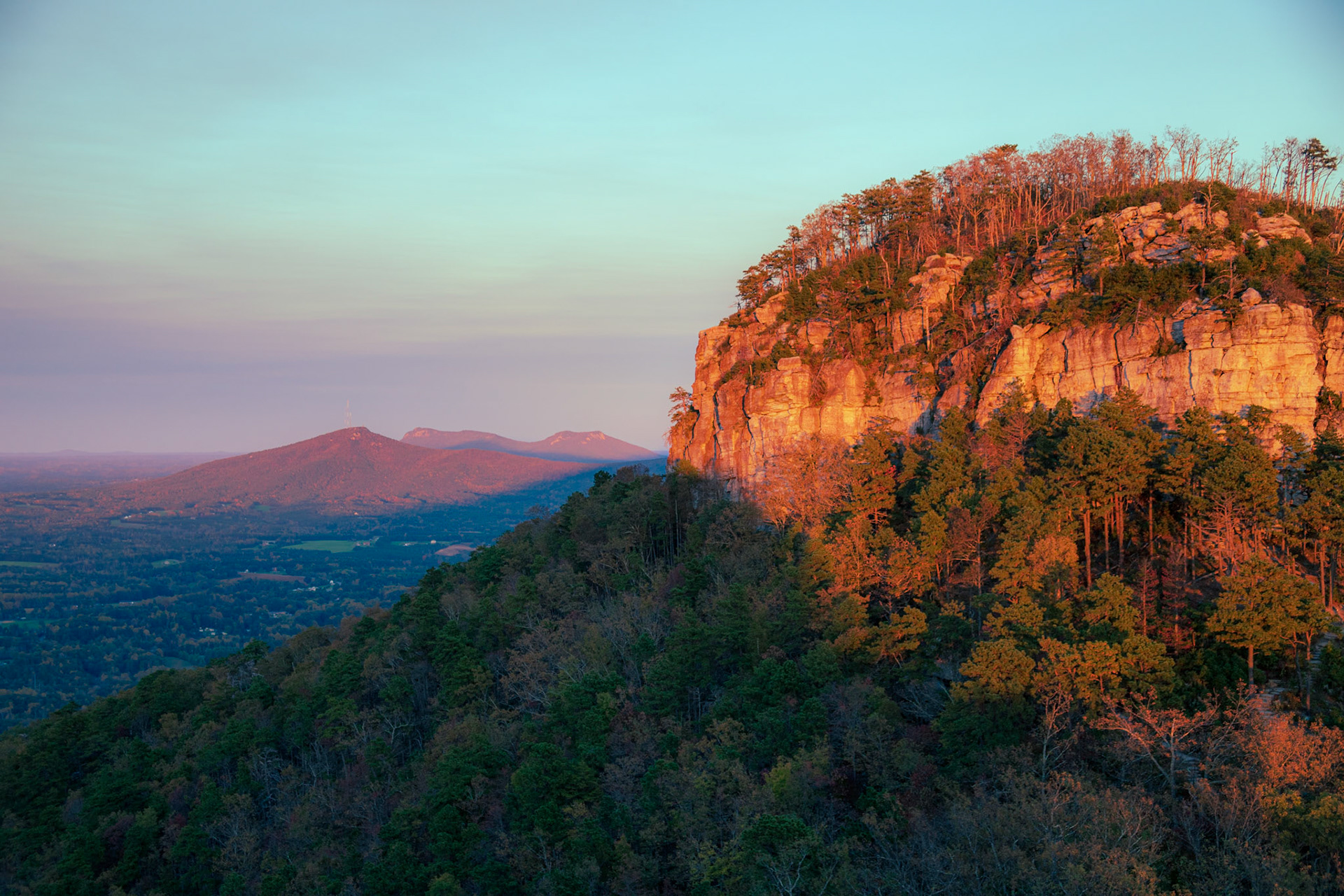 PIlot Mountain lit un with strong warm light from a sunset.
