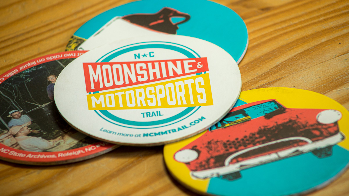 the collection of coasters with the back of the coaster displaying the logo and website address clearly visible.