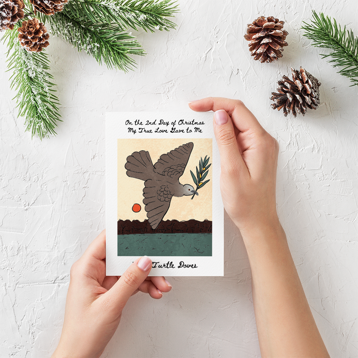 A person holding a greeting card with the illustration of a dove carrying an olive branch.