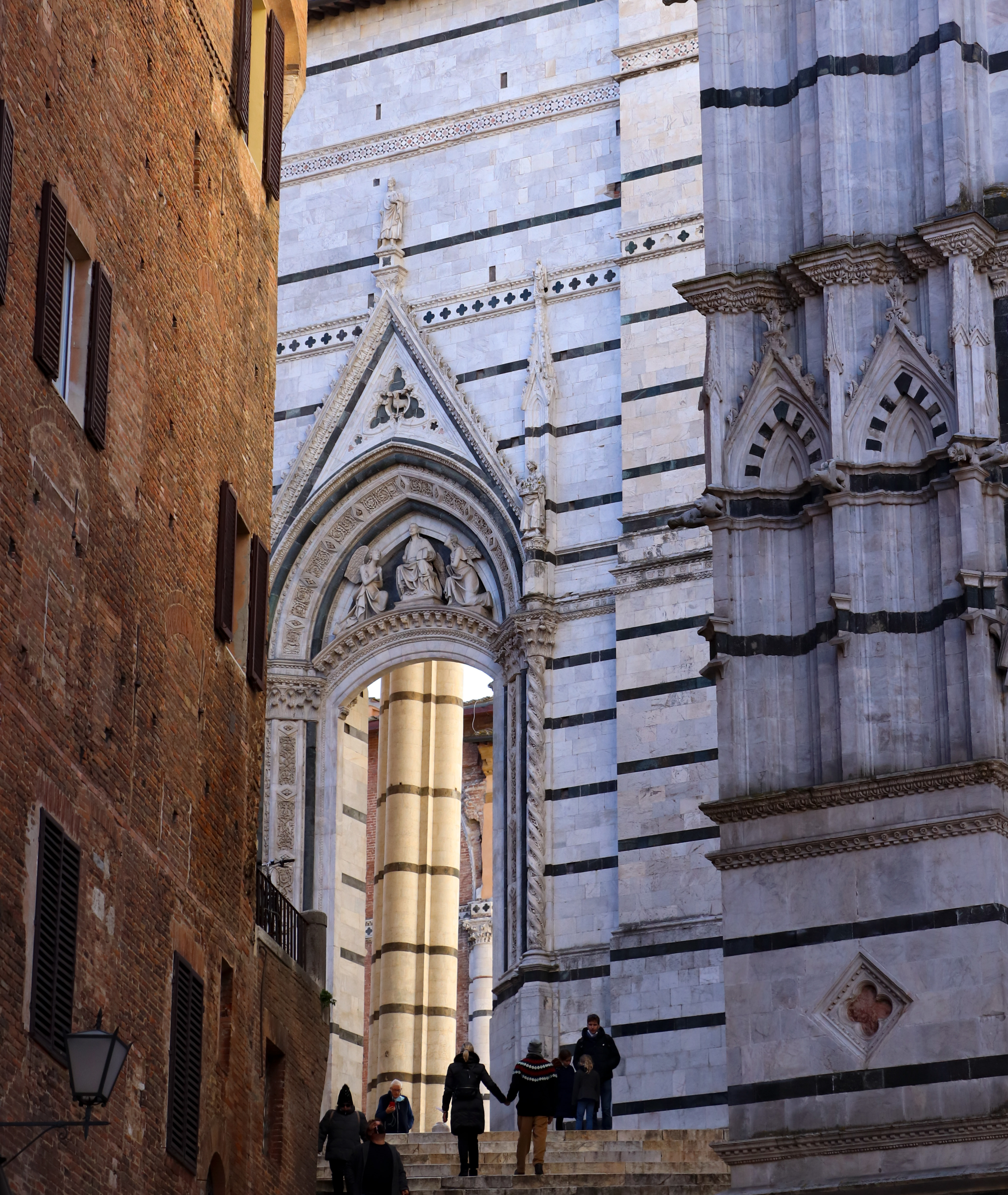 La Piazza del Duomo, Siena is full of narrow streets and intricate designs in the  architectire. It is a smaller city that is harder to get to so there are fewer  tourists, but the  Duomo holds one of a kind artwork and  interior detail.