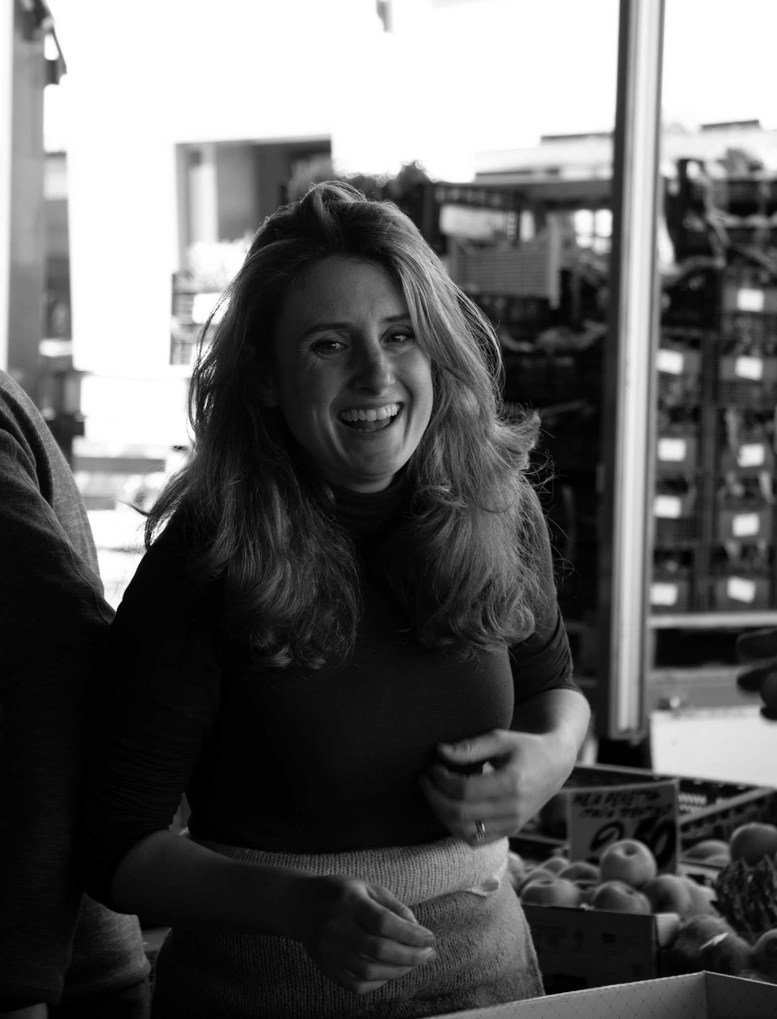 A vendor at Mercado di Sant'Ambrogio smiling with customers