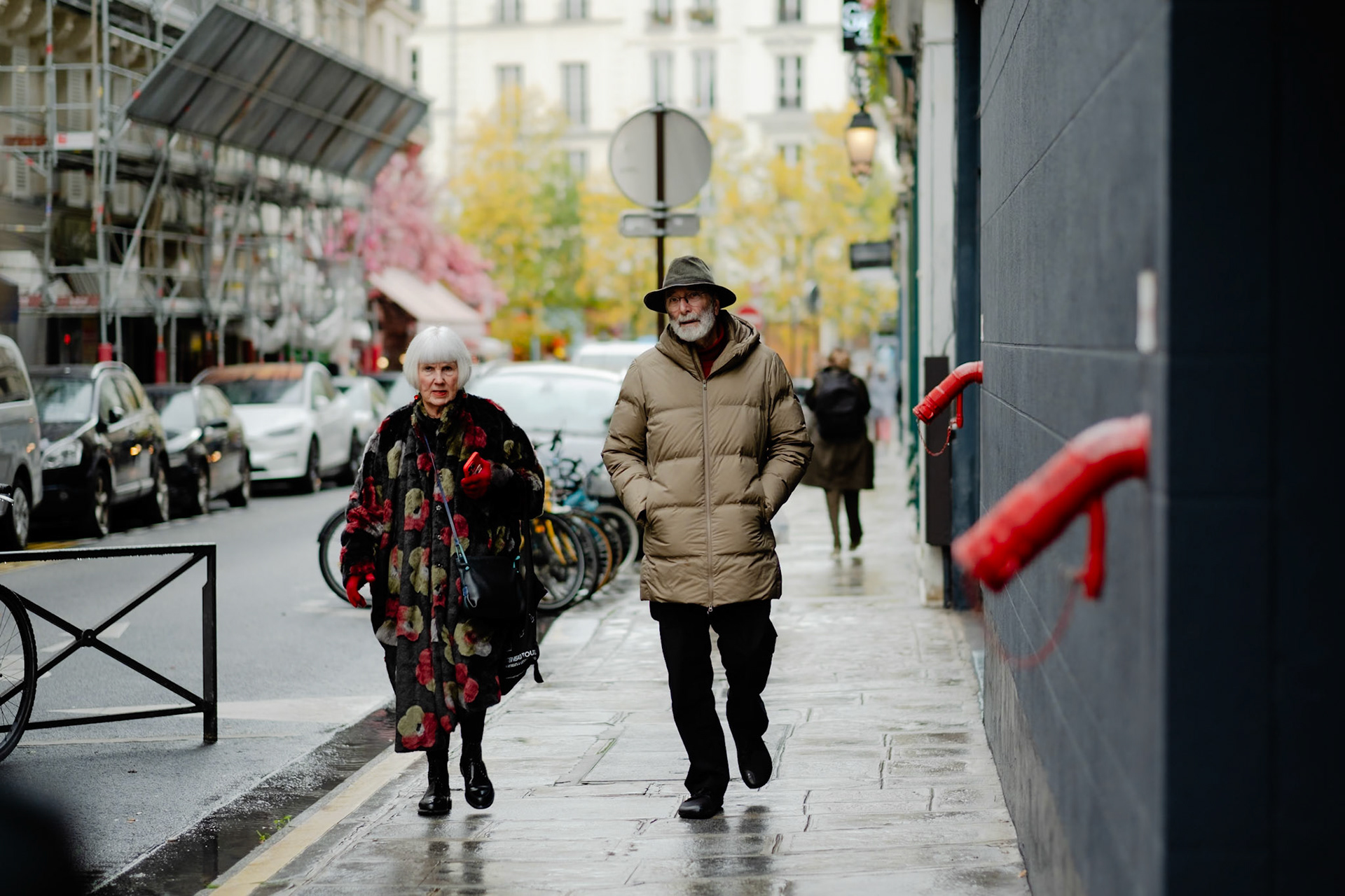 A stylish elderly couple strolling through the chic Marais district.