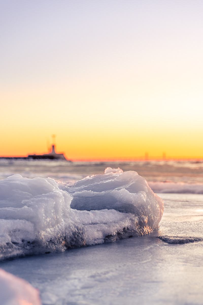 Snö och is solnedgång med lomma pir öresund och öresundsbron i bakgrunden