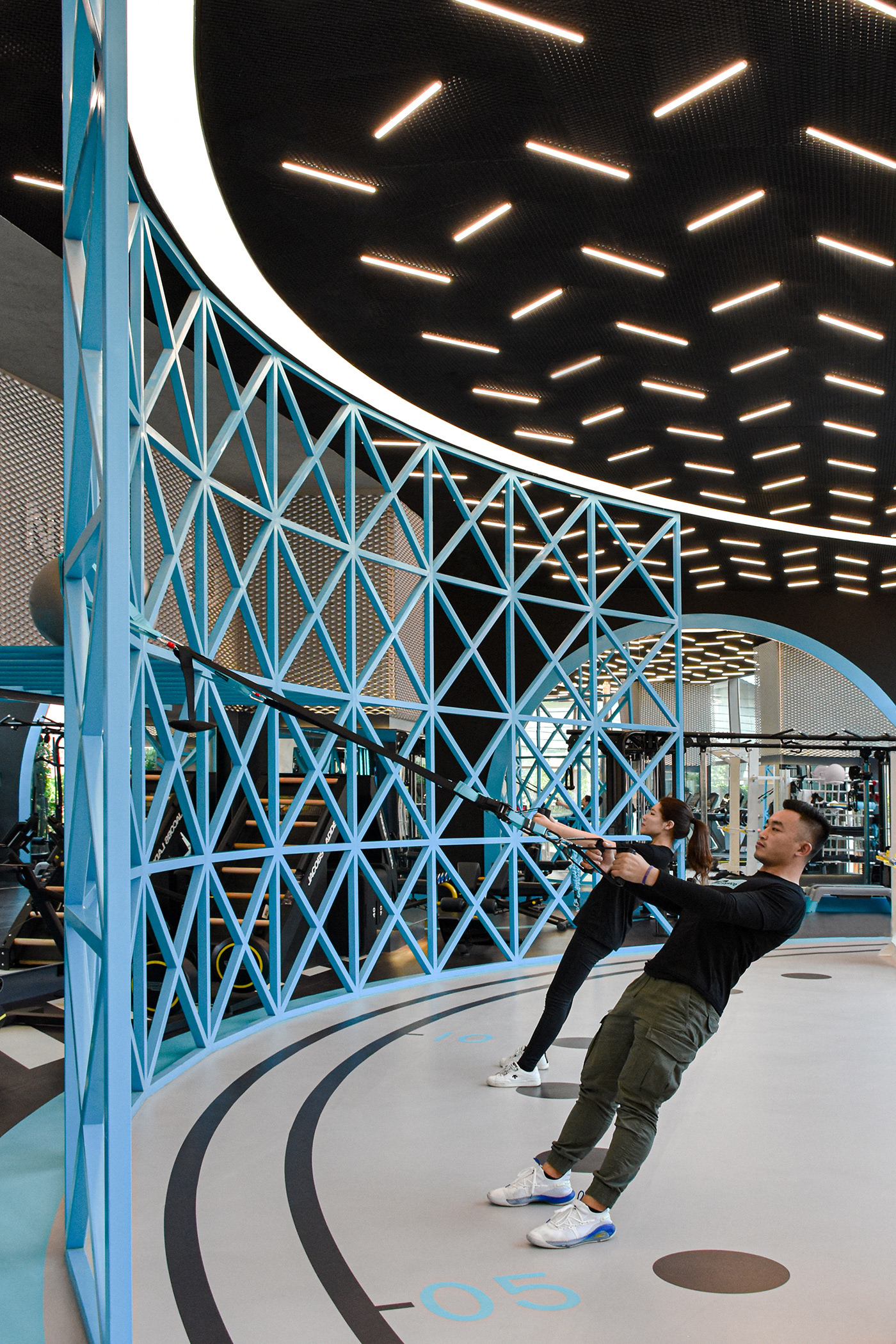 MFIT SPACE the large light blue colored lattice iron structure works as partition and training tool gym design by RAMOPRIMO
