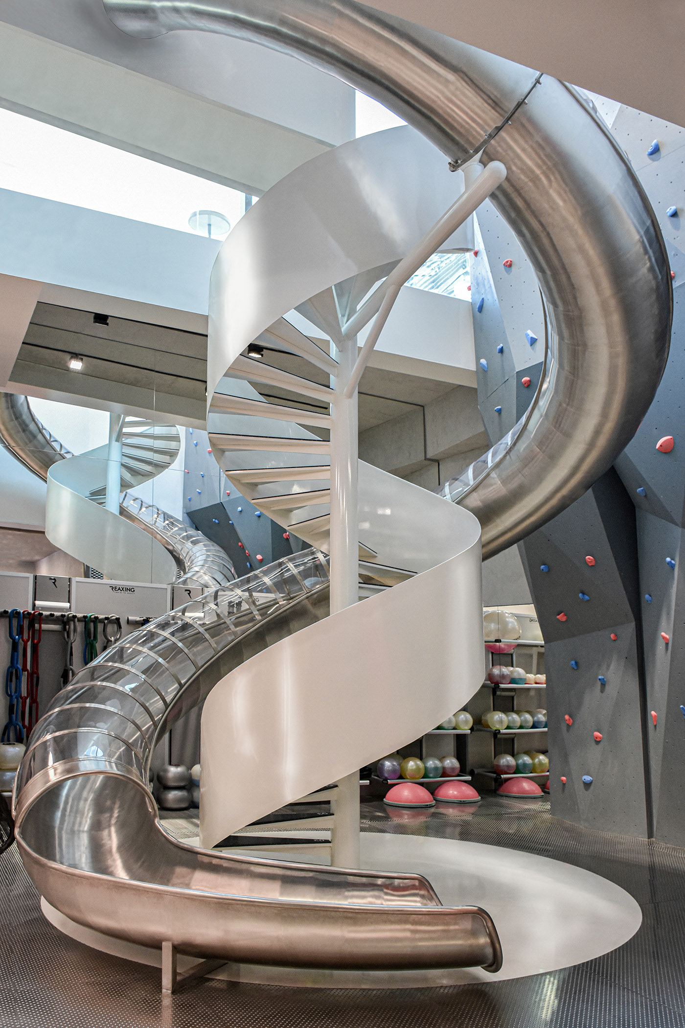 MFIT SPACE gym double high void with spiral staircase steel slide and climbing wall design by RAMOPRIMO