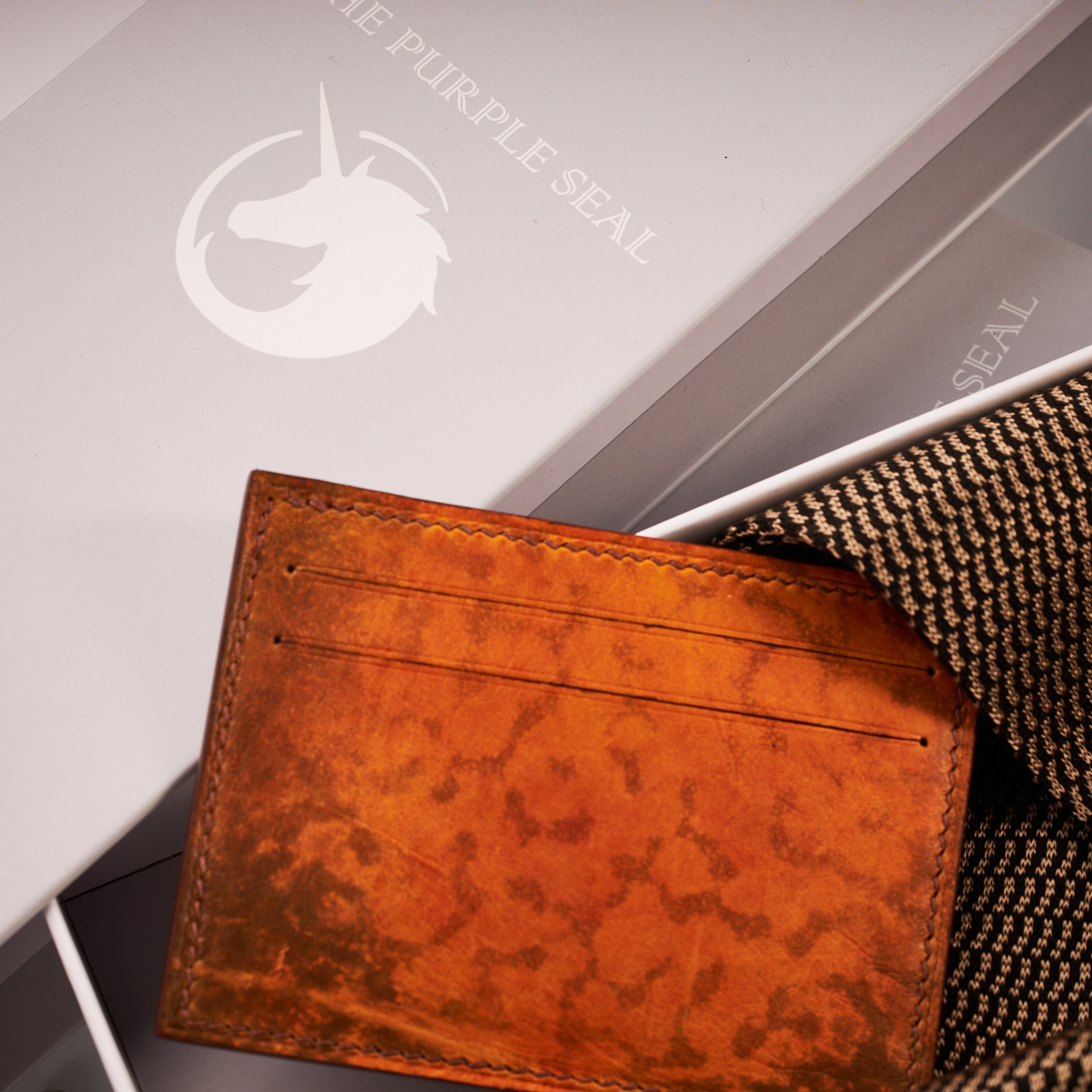 Luxury accessories Lifestyle image of leather cardholder and elegant dress socks by The Purple Seal - Orange and Brown