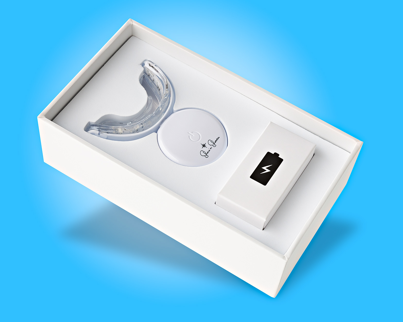 Dynamic and fresh image of teeth whitening device inside its box by Stefania Calderara