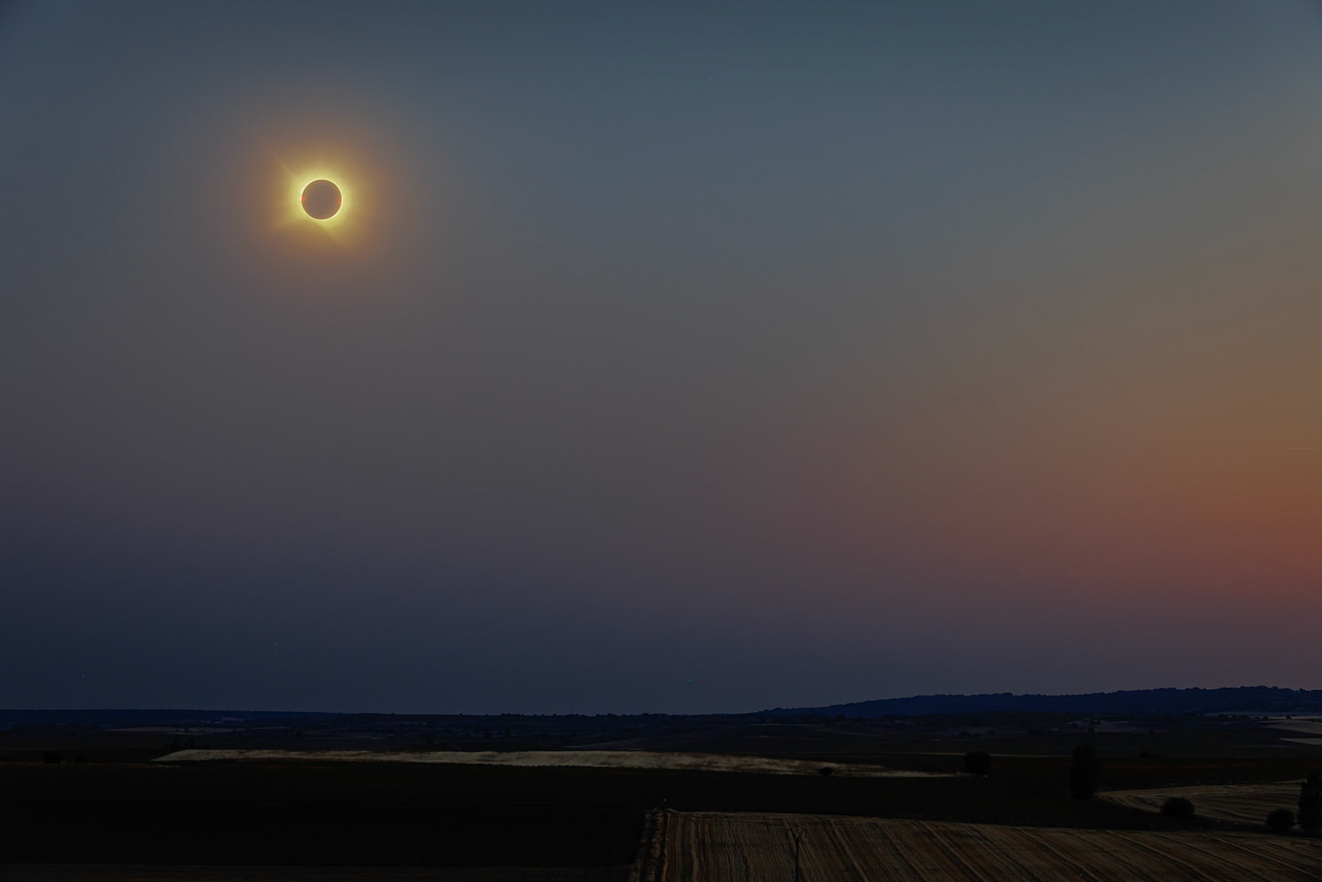 Total Eclipse with the sunset light at horizon and the stars in the sky