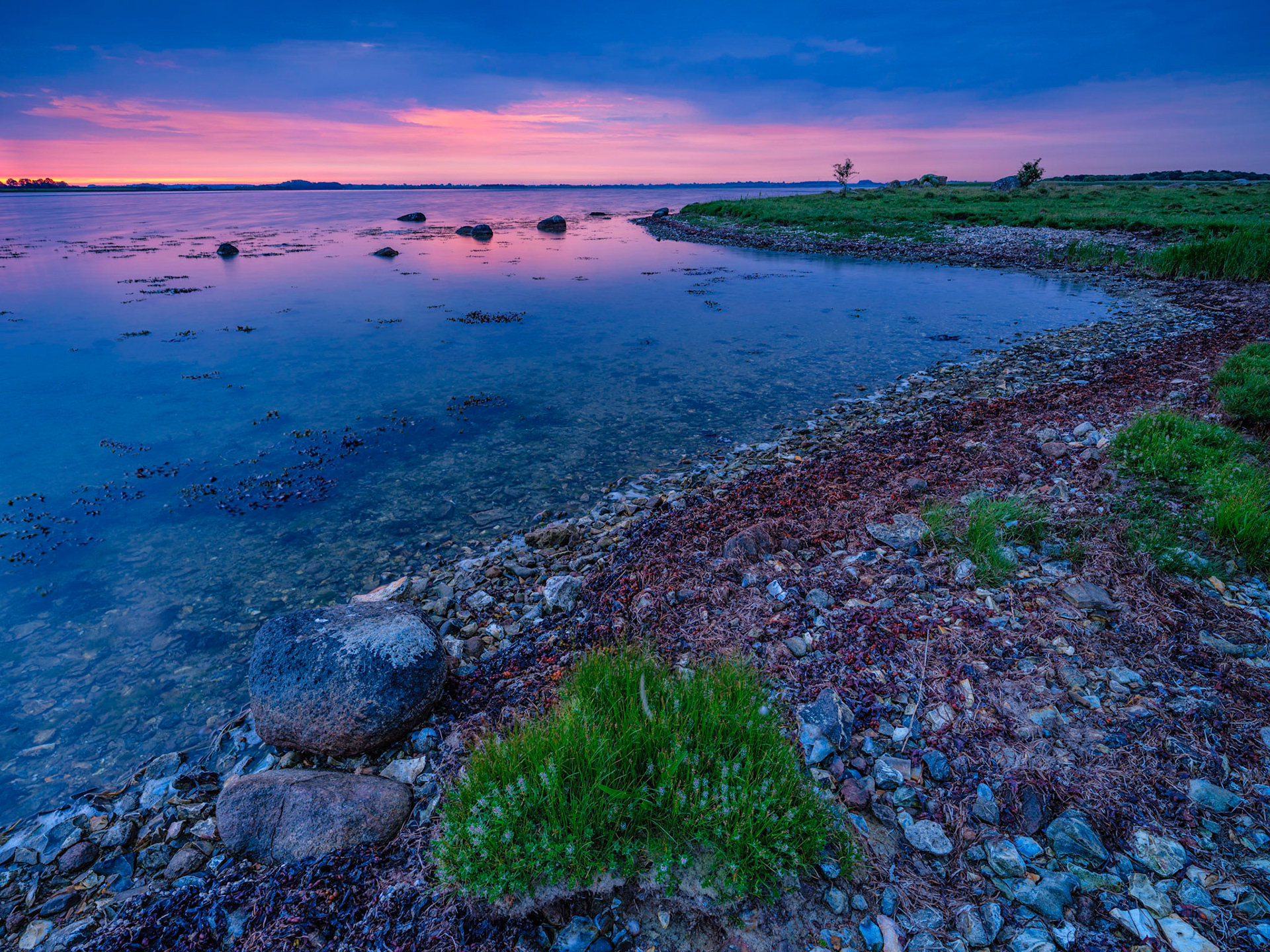 Skejten, Lolland - Denmark ..... has so many undiscovered motives, it is just a matter of getting up early and start to explore and you may find a new angle. I really love all the Flint (stones) in the waterline which makes this place much different from other coastal areas of Denmark. This particular morning I was lucky to have both the morning blue hour light and the warm colors of the rising Sun