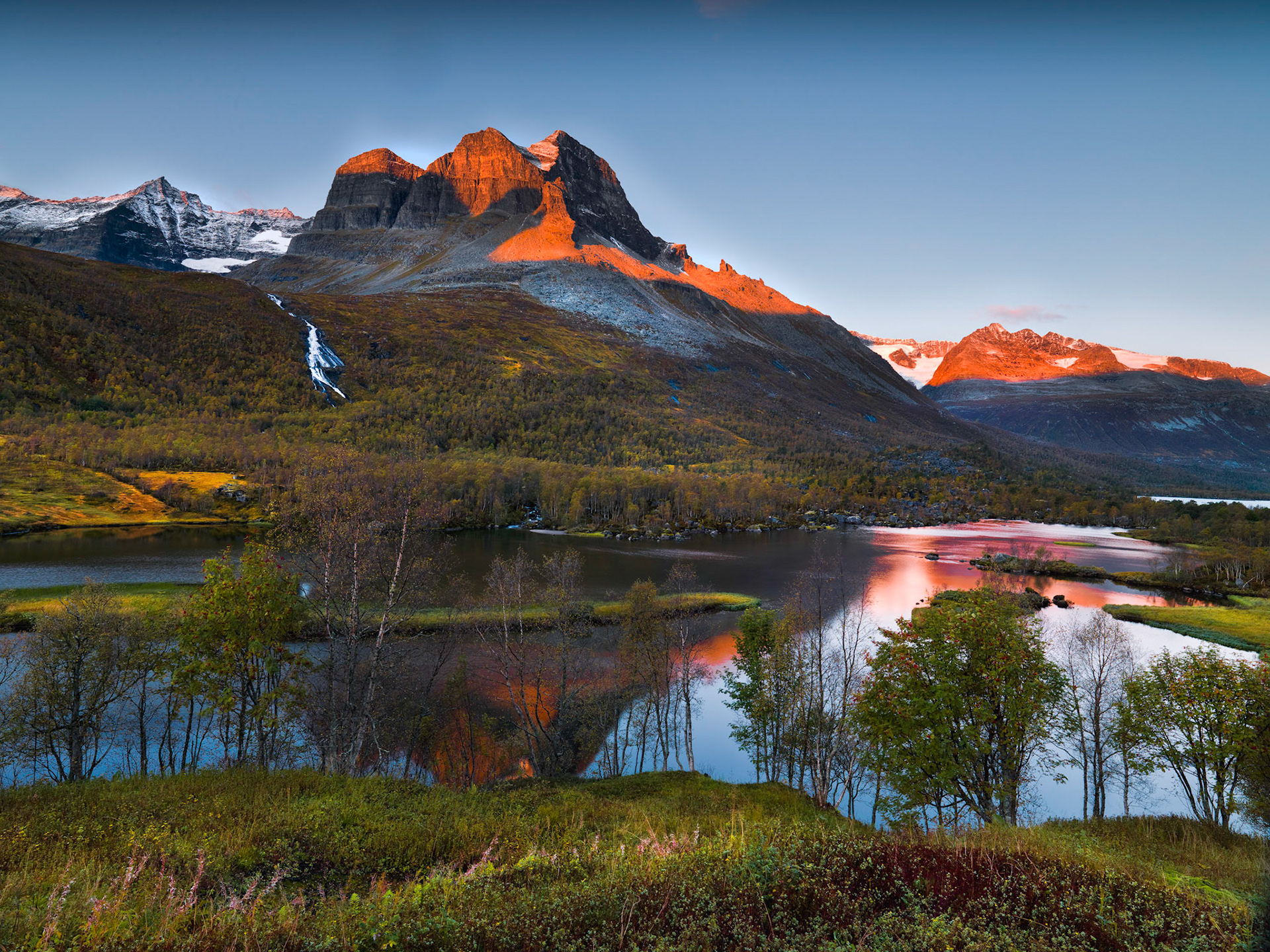 Morning sunrise at Innerdalen with Alpenglow on "Skarefejl" and "Vinufjel" glaciare in background on right and "Trolla" on left.