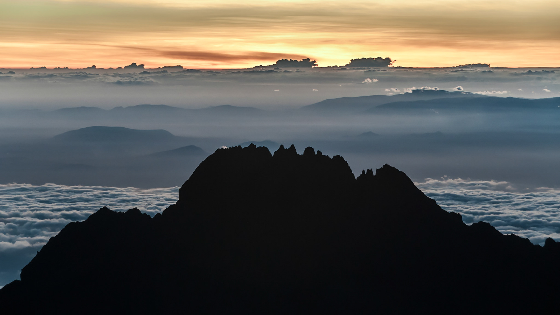 The early morning sun rising over Mawenzi looking back from the summit of Kilimanjro