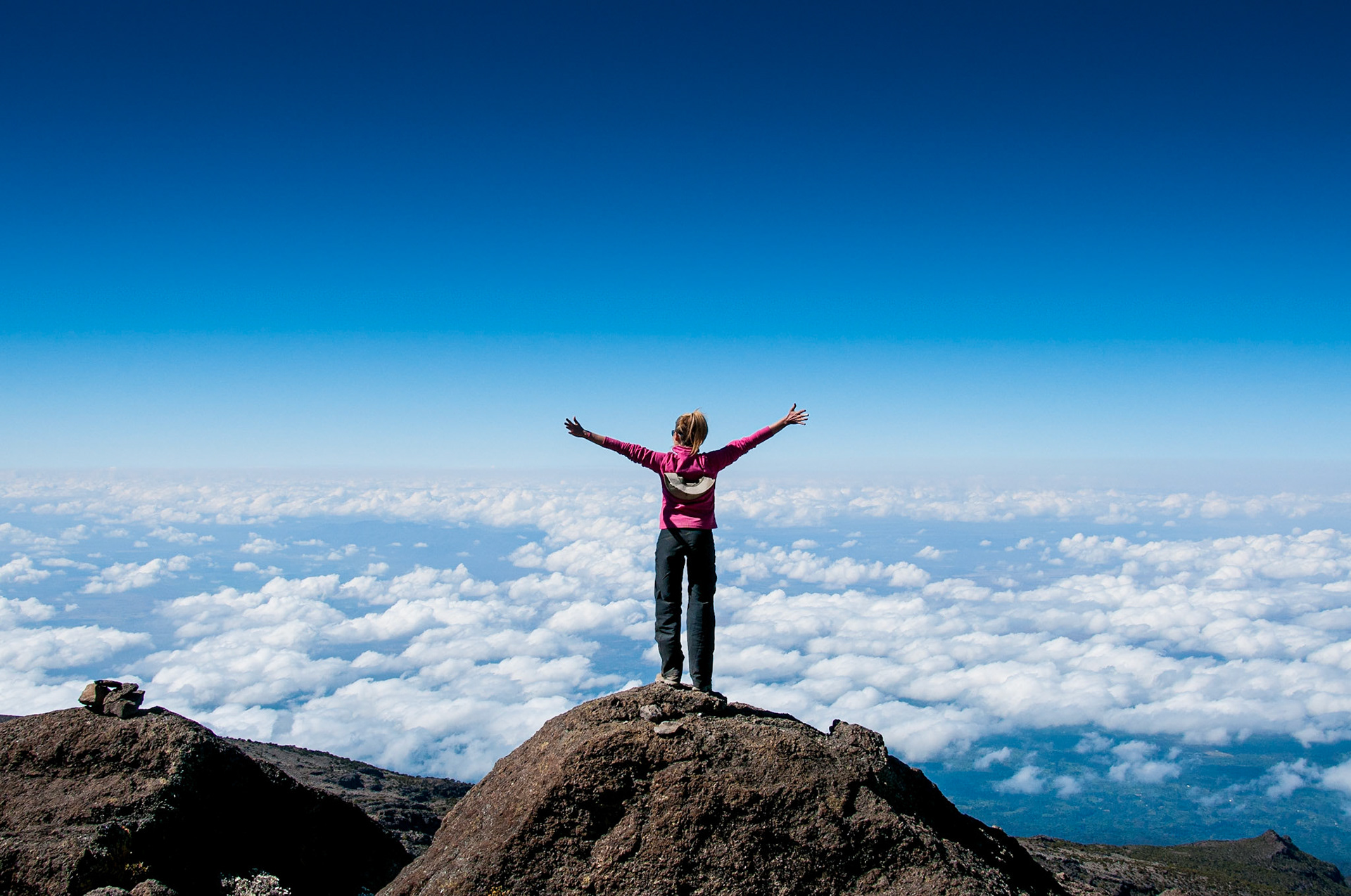 A happy trekker above the clouds on the route to the summit of Kilimanjaro