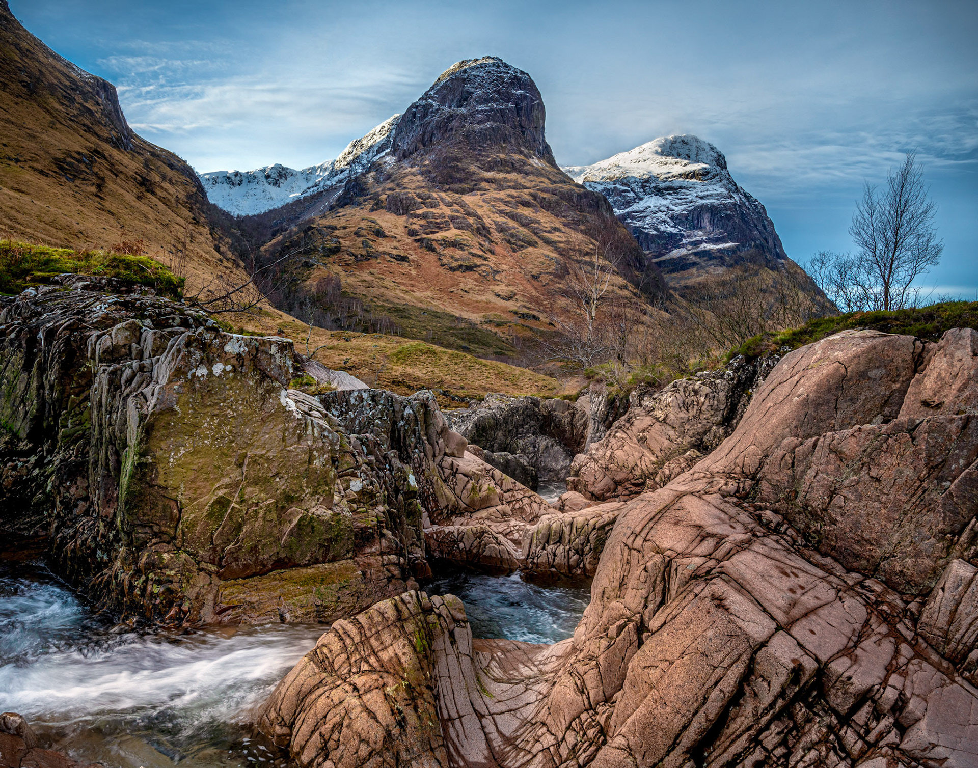 The River Coe flowing through Glen Coe  in winter with the group of mountains oknown as The Three Sisters in the background