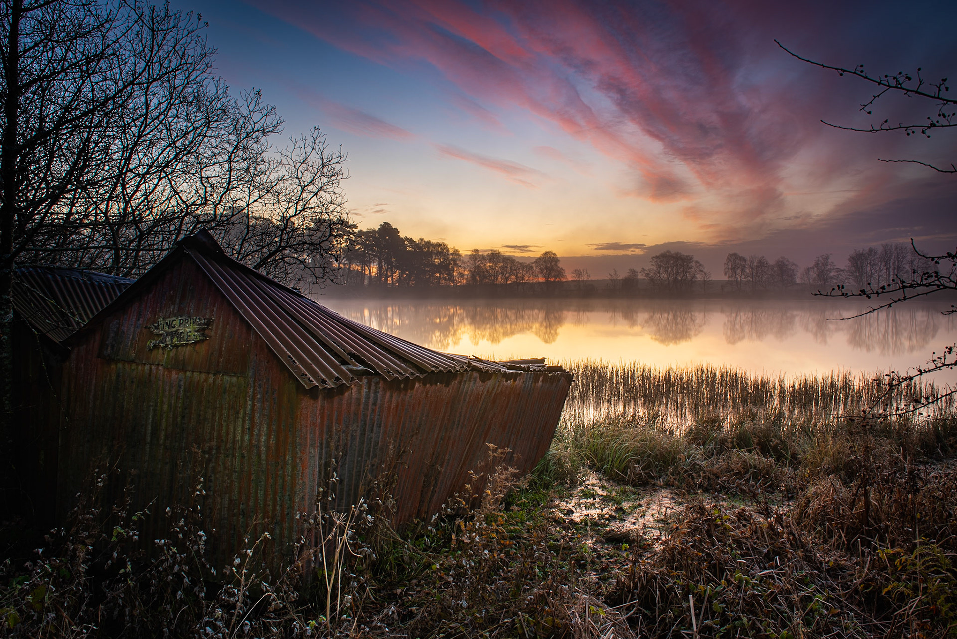 A misty morning just before sunrise at the old boat house at Alloch near Milton of Campsie, Scotland