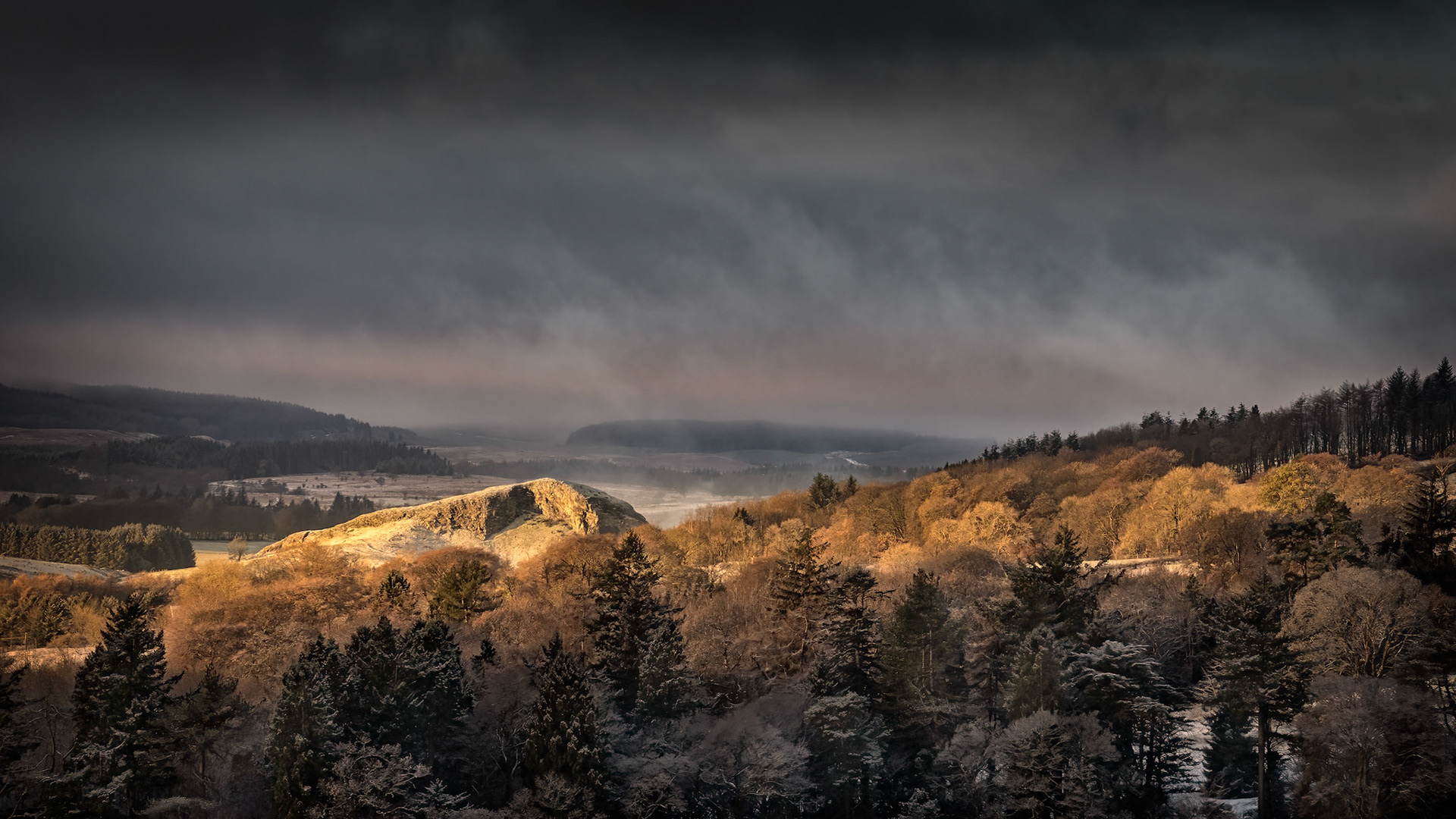 Dunglass in the winter sunlight. The hill is the remains of an old volcanic plug with interesting rock formations on its sides.