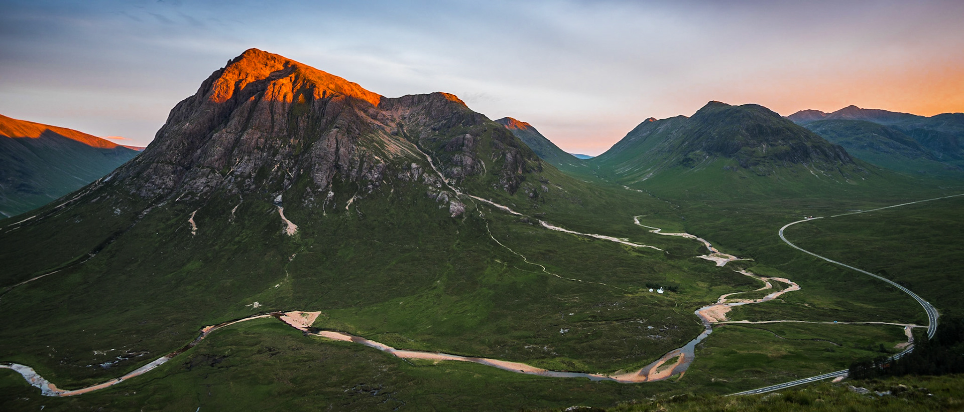 An alpenglow on the summit of Buachaille Etive Mor in Glencoe, Scotland on midsummer evening