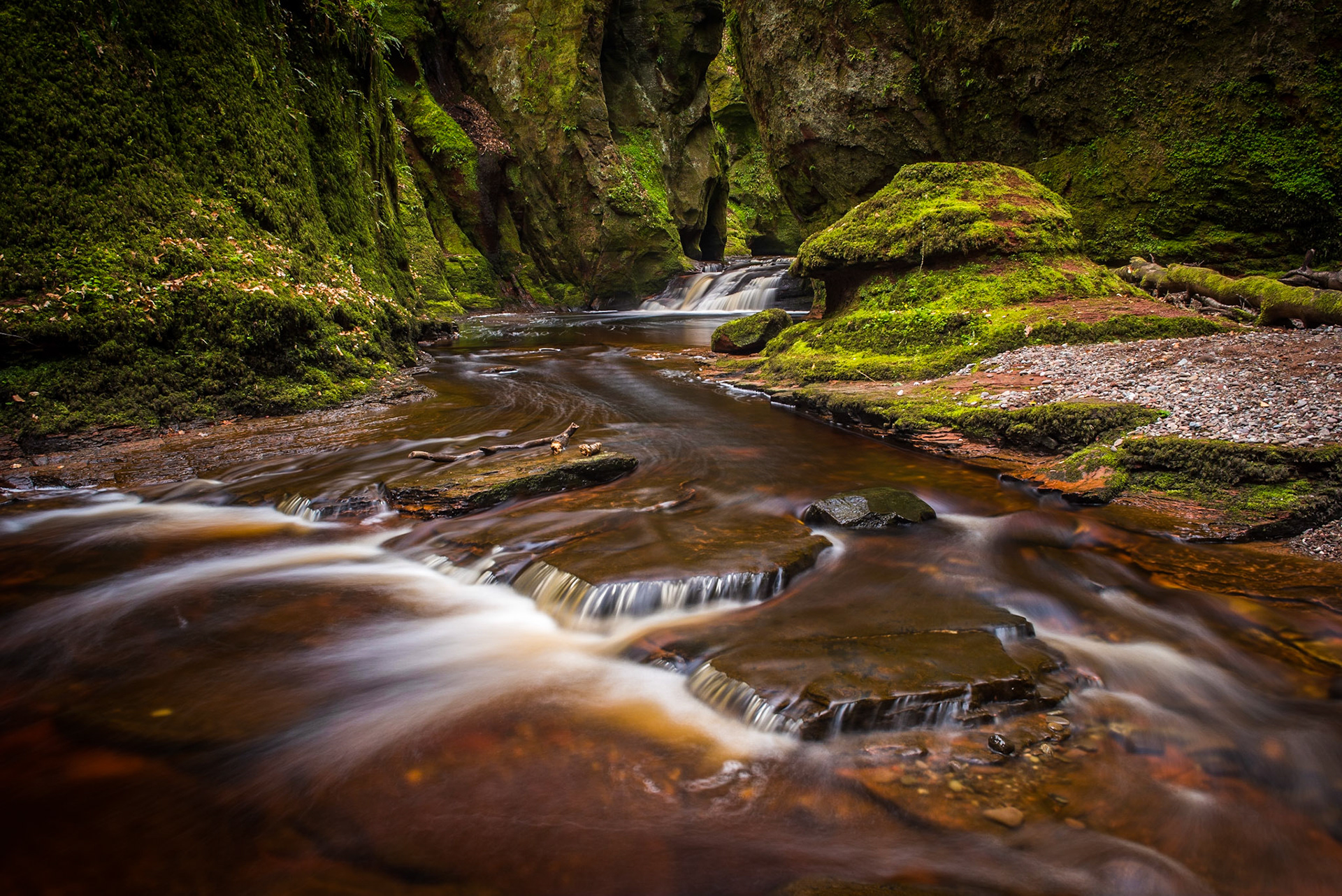 The gorge at Finnich Glen, also known as Devils Pulpit near Killearn Scotland.  The river is a red colour from the minerals and rocks. It is  also a popular location for many films such as Outlander