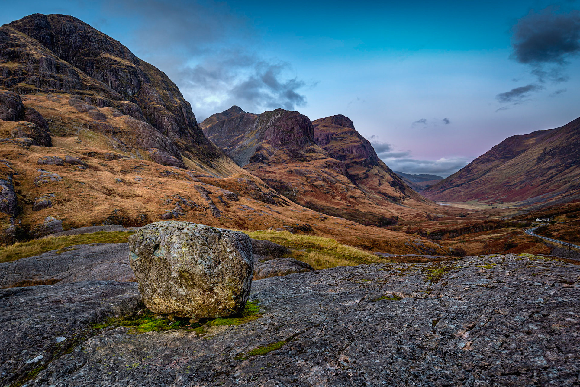 Sunrise on a glacial erratic rock left on a rocky ledge on the slopes of Glencoe in Scottish Hughlands
