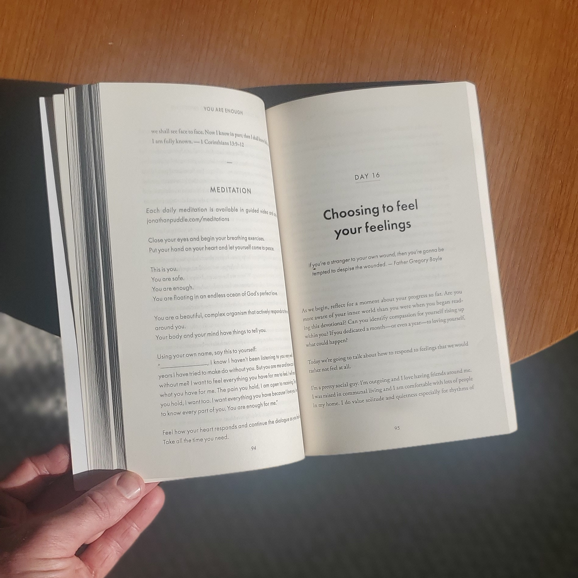 Open book showing pages from "You Are Enough" with a meditation section on the left page and new chapter "Day 16: Choosing to feel your feelings" on the right page.
