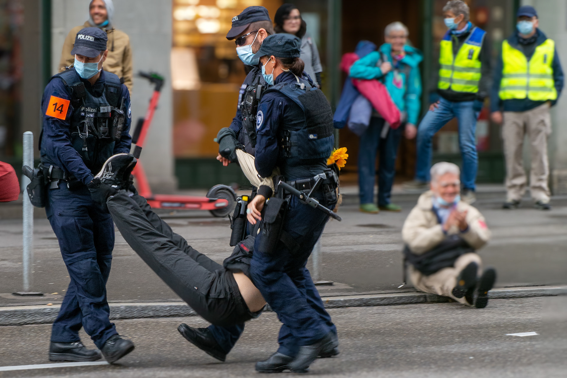 Intervention de police lors d'une manifestation en Suisse, manifestant évacué par trois agents 