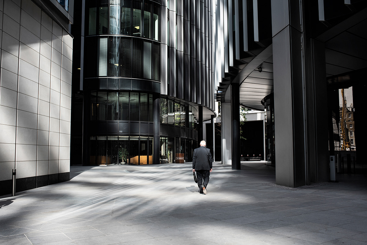 Man walking in empty, City of London Financial District, London.  City centre could become a ghost town in the future, since home working - which was initially brought in as a temporary measure in lockdown - could become a more permanent state of affairs. This could allows firms to cut their rent and utilities costs, while offering employee major flexibility.  Remote working – complete with its Zoom conference calls – has been judged a success by some businesses, who are now questioning the need for huge office buildings. 