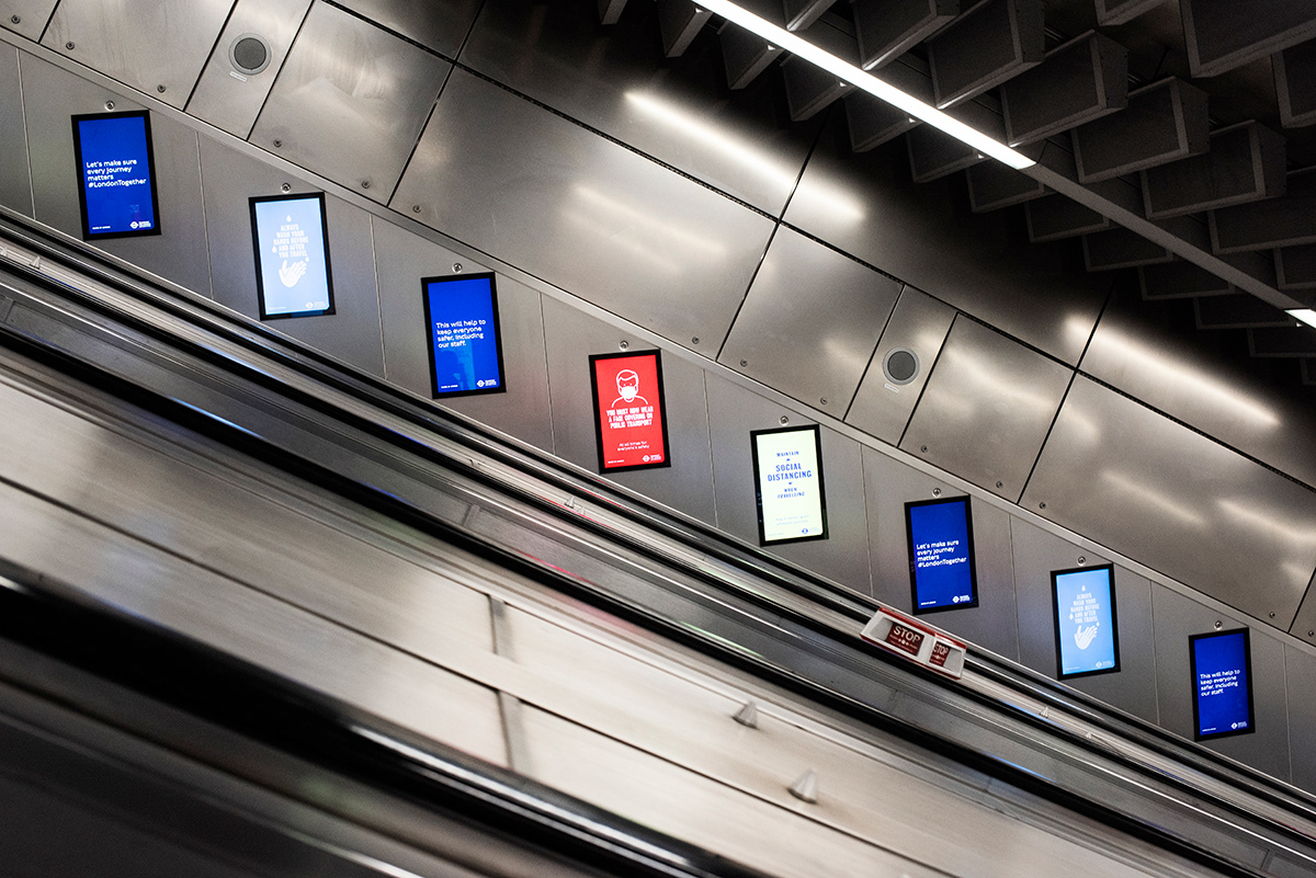 Signage on the side of tube escalators, advising people to wash their hands, keep 2 metres distance, wear face masks, etc. Central London.  The TFL communication campaign consists of posters and announcements around the network, distancing stickers, in place at the busiest and largest stations on the London Underground, London Overground, DLR and Tram networks. More social distancing markers at bus stops and shelters are also being installed across London. Dozens of stations have had new one-way and queuing systems to help control the flow of customers through the station, helping passengers to socially distance, and more than 500 hand sanitisers in Tube station ticket halls have been installed.