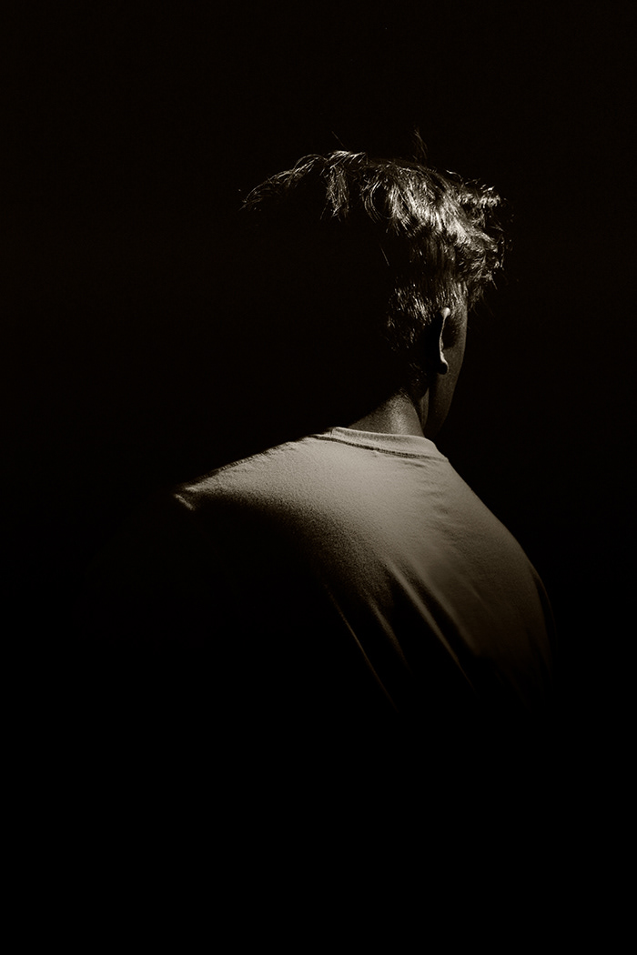 Man looking over his shoulder with his back to the camera.