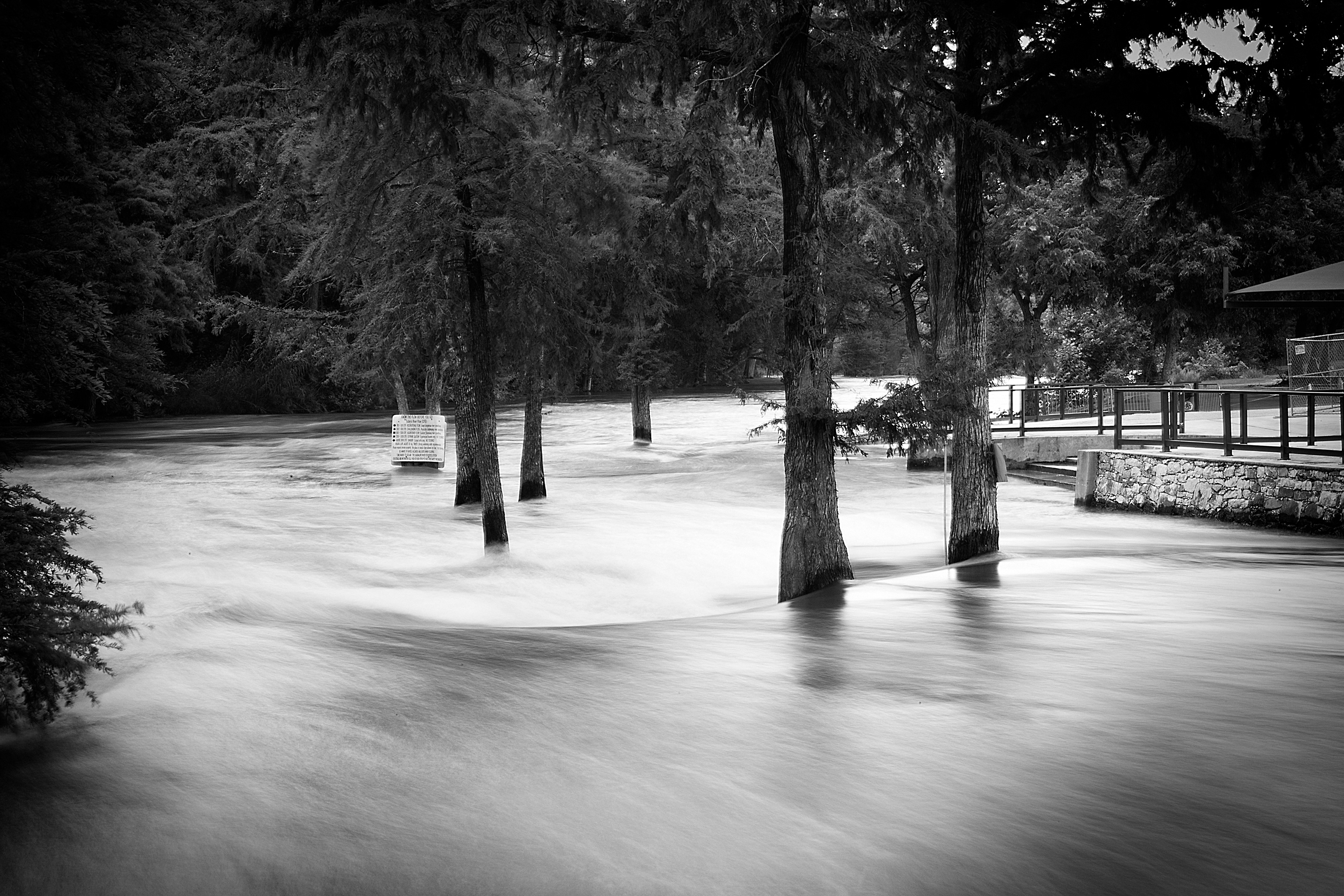 Long exposure having a calming effect on the raging flood waters. Gruene, TX.