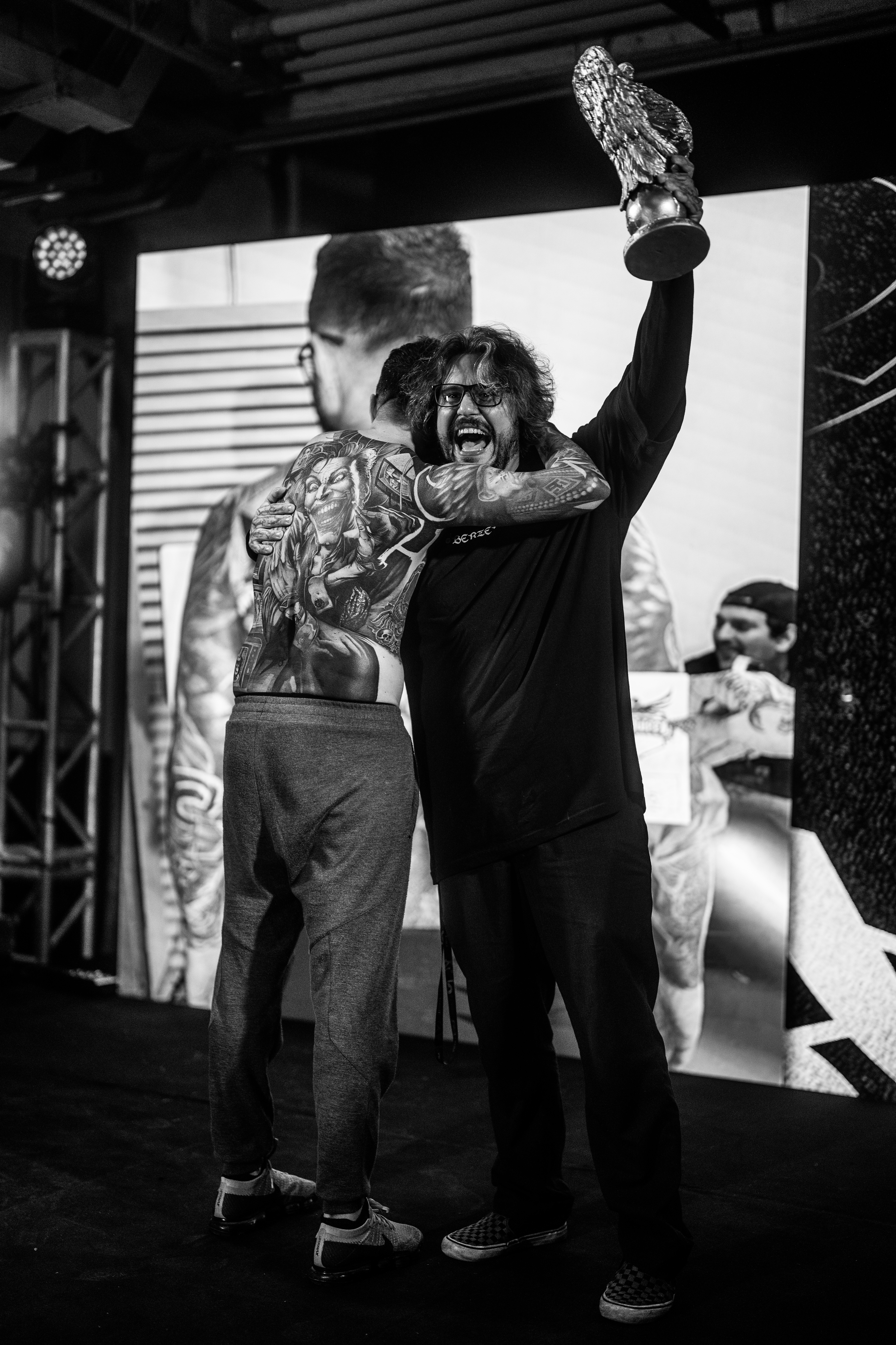 nicho recebendo prêmio de melhor fechamento de costas na tattoo week brasília 