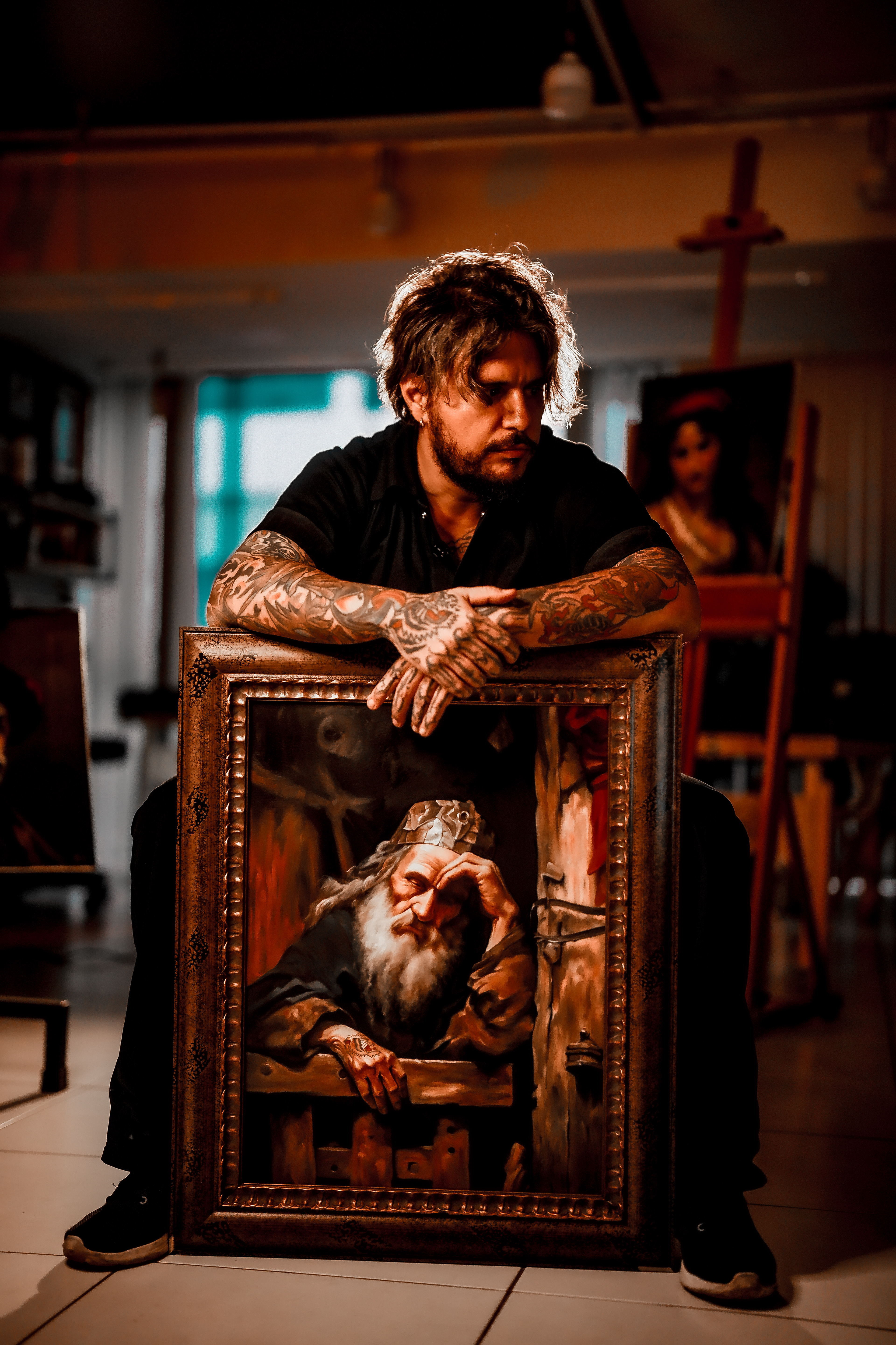 Retrato do artista Nicho com uma de suas obras.
