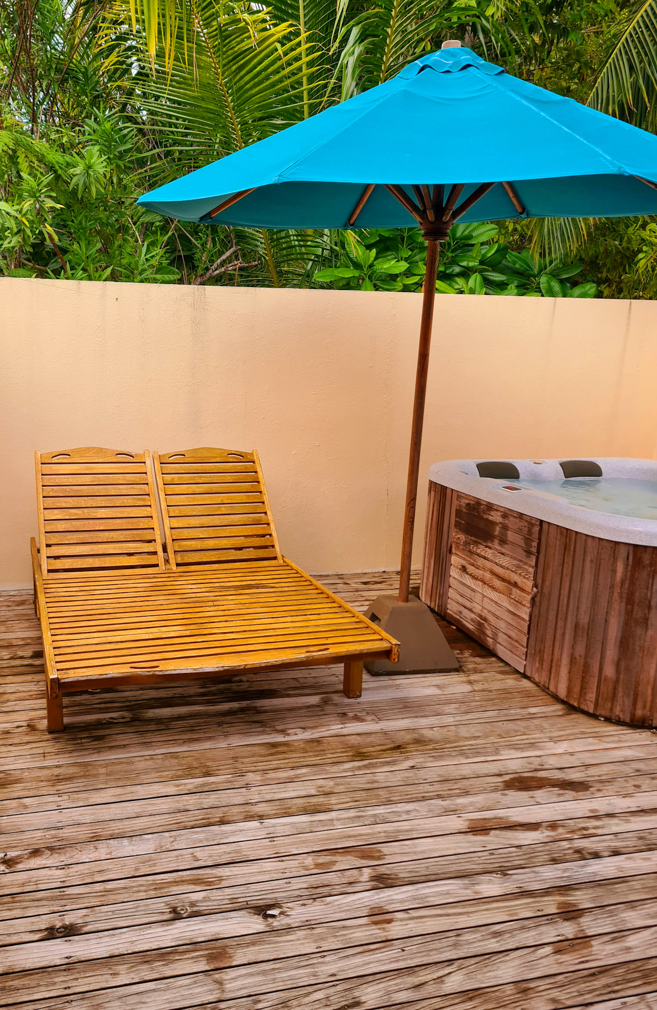 Bag-terrassen med jacuzzi og liggestole - her i regnvejr