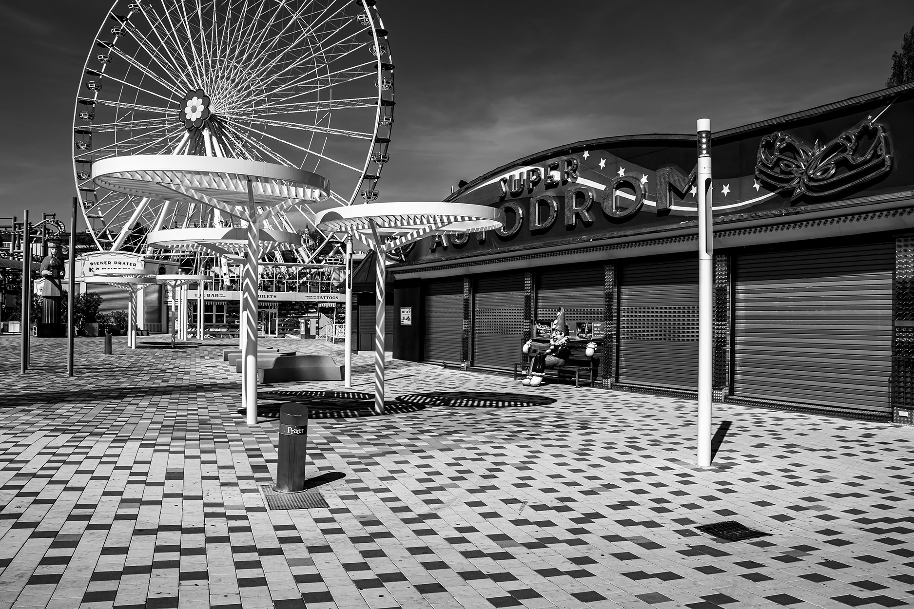 Closed amusement park at Vienna Prater during the 2020 COVID-19 lockdown – empty fairground with Ferris wheel and shuttered attractions, no visitors