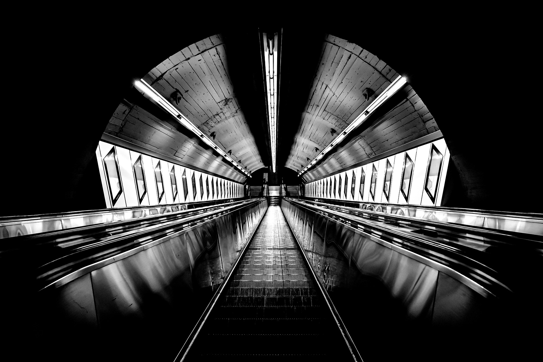 Empty escalator at Karlsplatz subway station in Vienna during the 2020 COVID-19 lockdown – underground station with no passengers and strong architectural symmetry