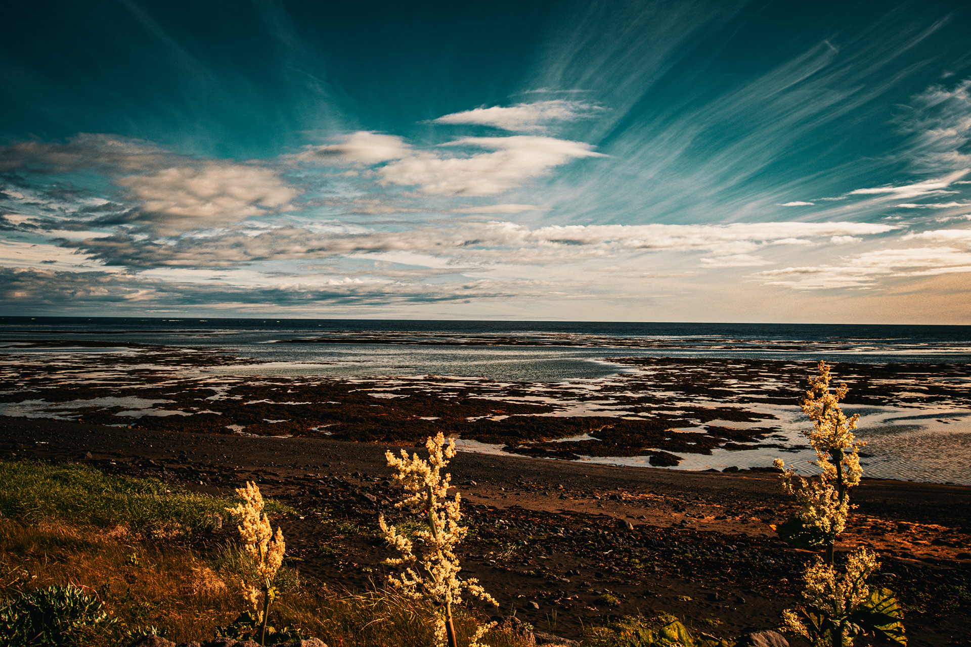 Fine art seascape from Iceland’s South Coast featuring dramatic sky, tidal pools, coastal textures and warm evening light.