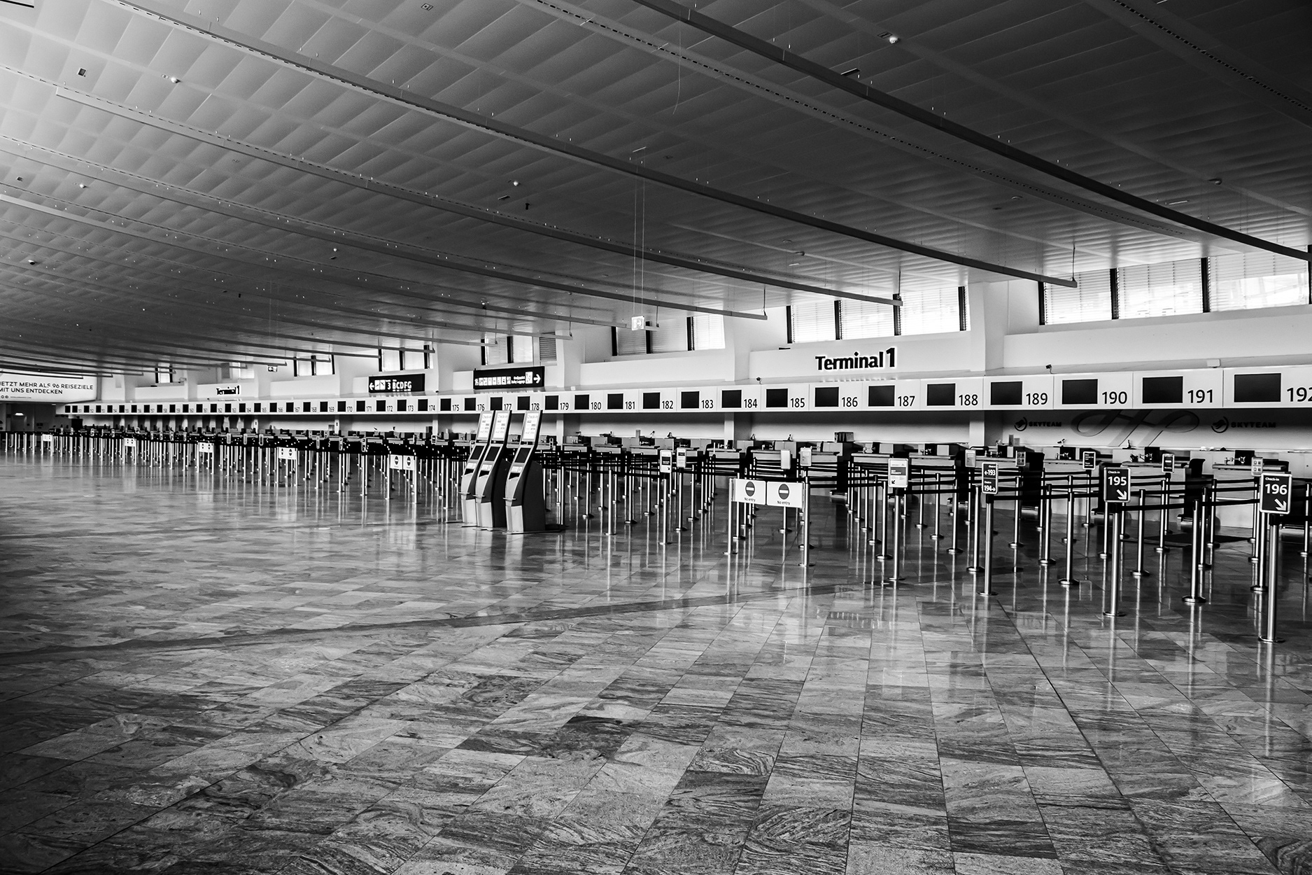 Empty check-in area at Vienna International Airport during the 2020 COVID-19 lockdown – deserted terminal with self-service kiosks and no passengers