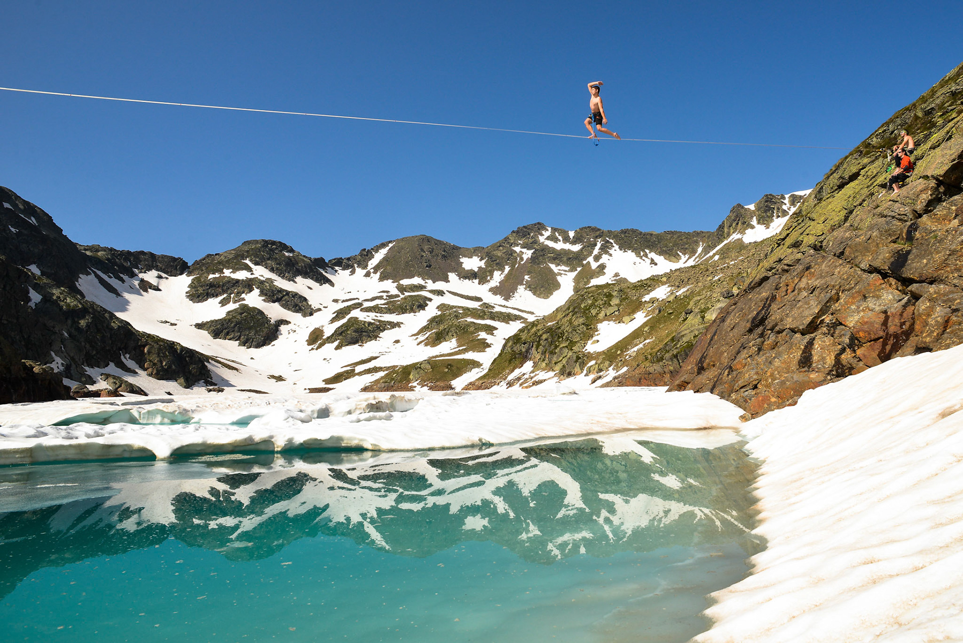 In french pyrenees (south of France), several members of the french extreme sports team pyrenaline, install and walk a slackline above a frozen lake at 2400 meters high. Auzat - France - july 2013.Dans les Pyrénées françaises, plusieurs membres de l'équipe de sports extrêmes Pyrénaline installent et marchent sur une slackline au dessus d'un lac gelé à 2400 mètres d'altitude. Auzat - France - Juillet 2013.