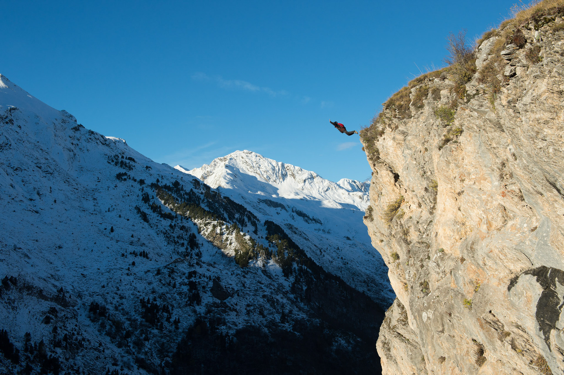 GAVARNIE, FRANCE - NOVMBER 17: a man with a parachute doing Base jump from a cliff in Gavarnie, Occitanie, Gavarnie, France on november 17, 2014 in Gavarnie, france.