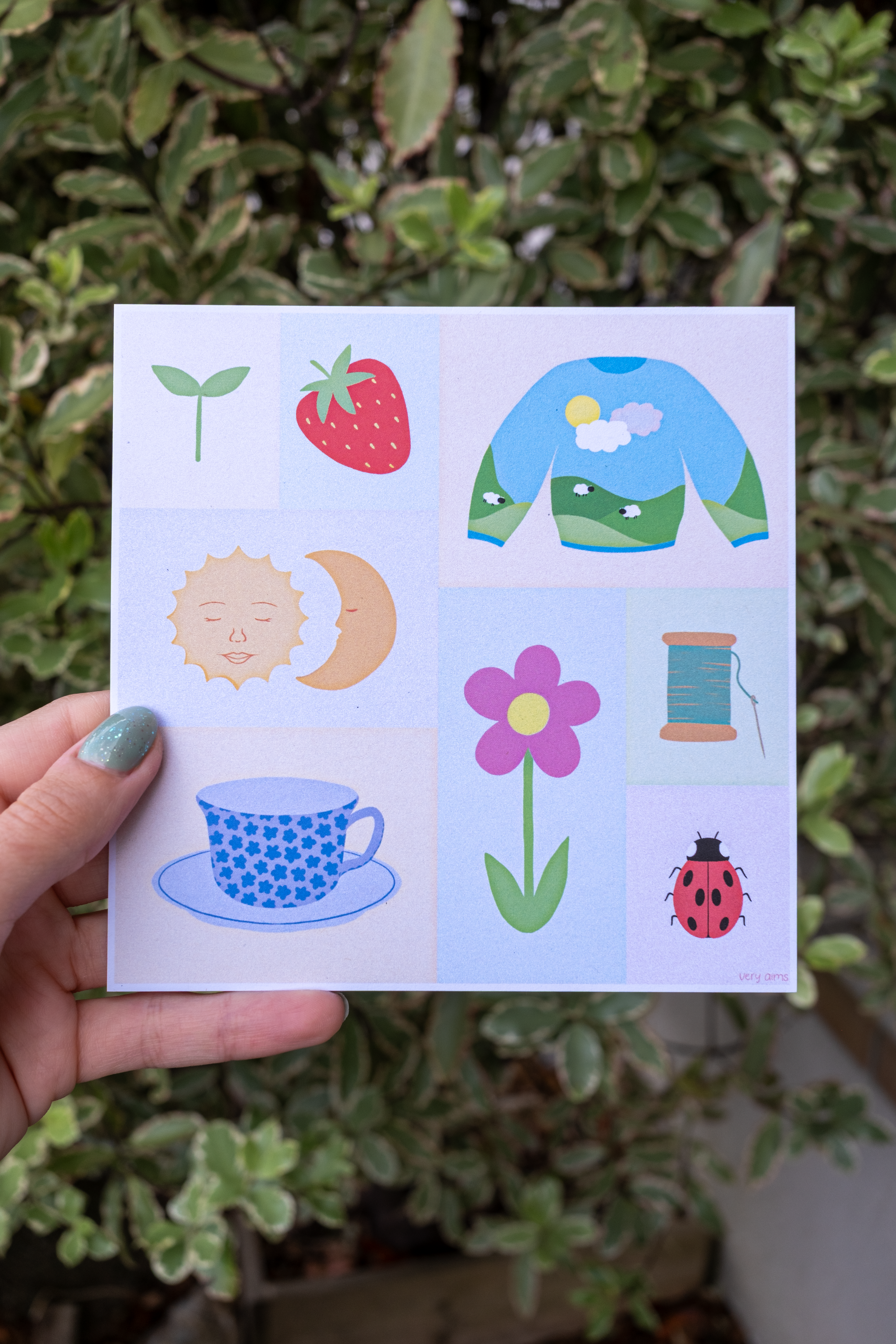 Cosy Home Print, a square digital print based on things that bring me joy, in a structured format, featuring items such as a strawberry, wooly jumper, thread, the sun and moon and a ladybug