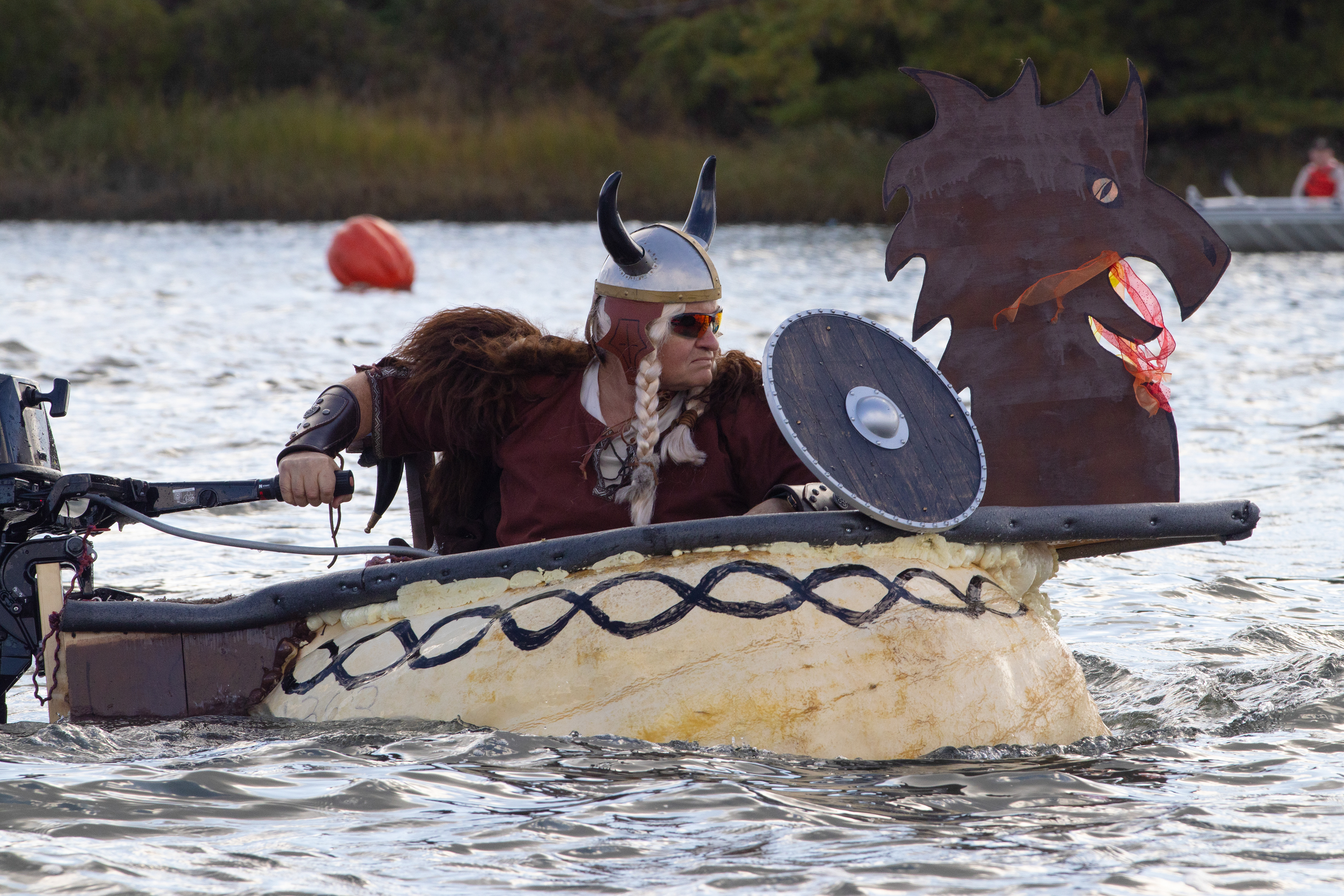 A racer dressed as a viking races other motorized pumpkin boats at the Damariscotta Pumpkinfest Regatta on Oct. 9, 2023. The regatta is a tradition in the coastal Maine town where people come from all over the country to race boats made out of giant pumpkins. The pumpkins are often painted and decorated while the racing teams dress up to match the theme.