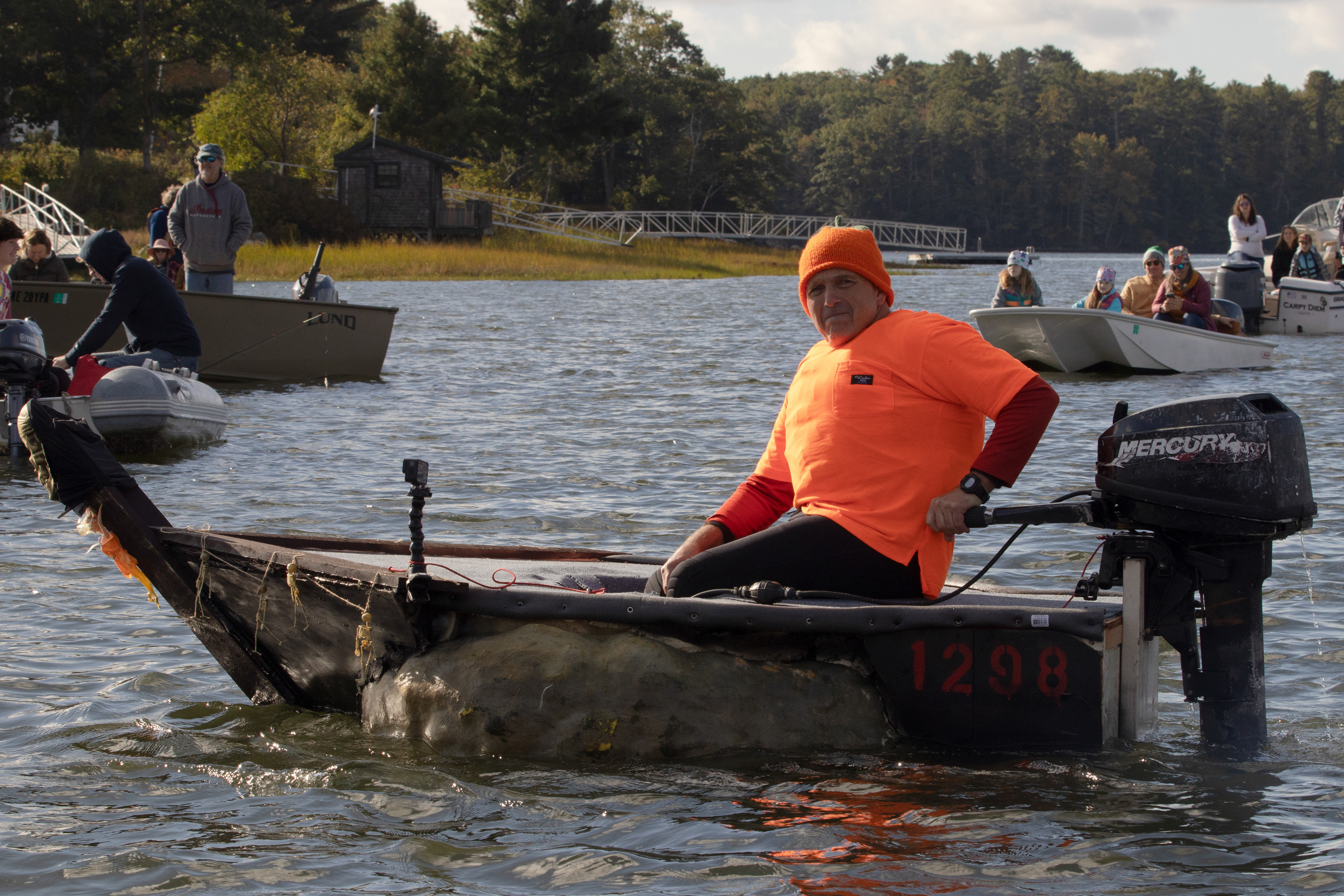 Buzz Pinkham, the first person in Damariscotta to captain a pumpkin boat in the harbor, sits in his motorized pumpkin boat at the Damariscotta Pumpkinfest Regatta on Oct. 9, 2023. The regatta is a tradition in the coastal Maine town where people come from all over the country to race boats made out of giant pumpkins. The pumpkins are weighed and painted, and the racing teams often dress up to race their pumpkin boats in the harbor.