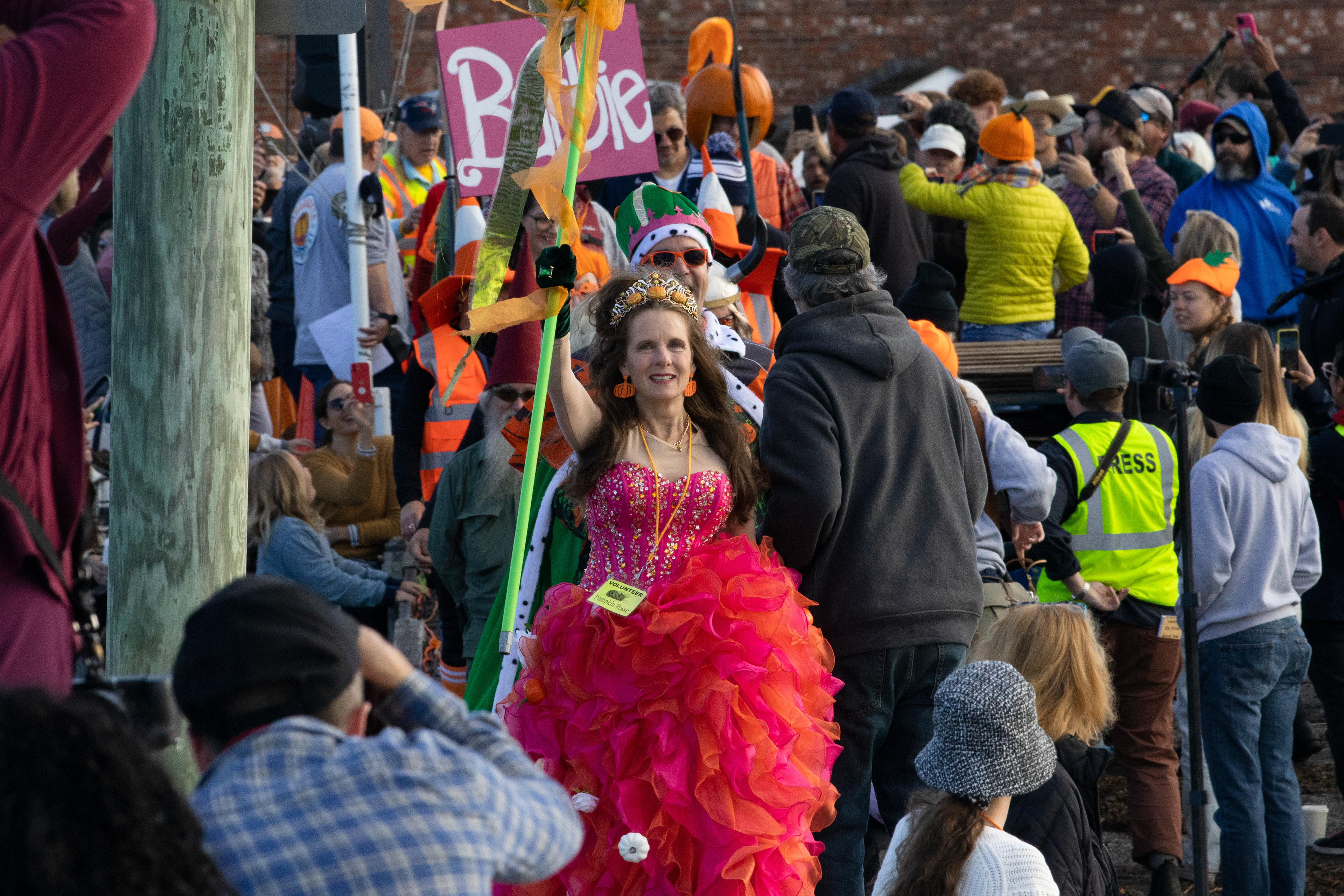 The Pumpkin Queen leads the paddlers to their pumpkin boats at the Damariscotta Pumpkinfest Regatta on Oct. 9, 2023. The regatta is a tradition in the coastal Maine town where people come from all over the country to race boats made out of giant pumpkins.